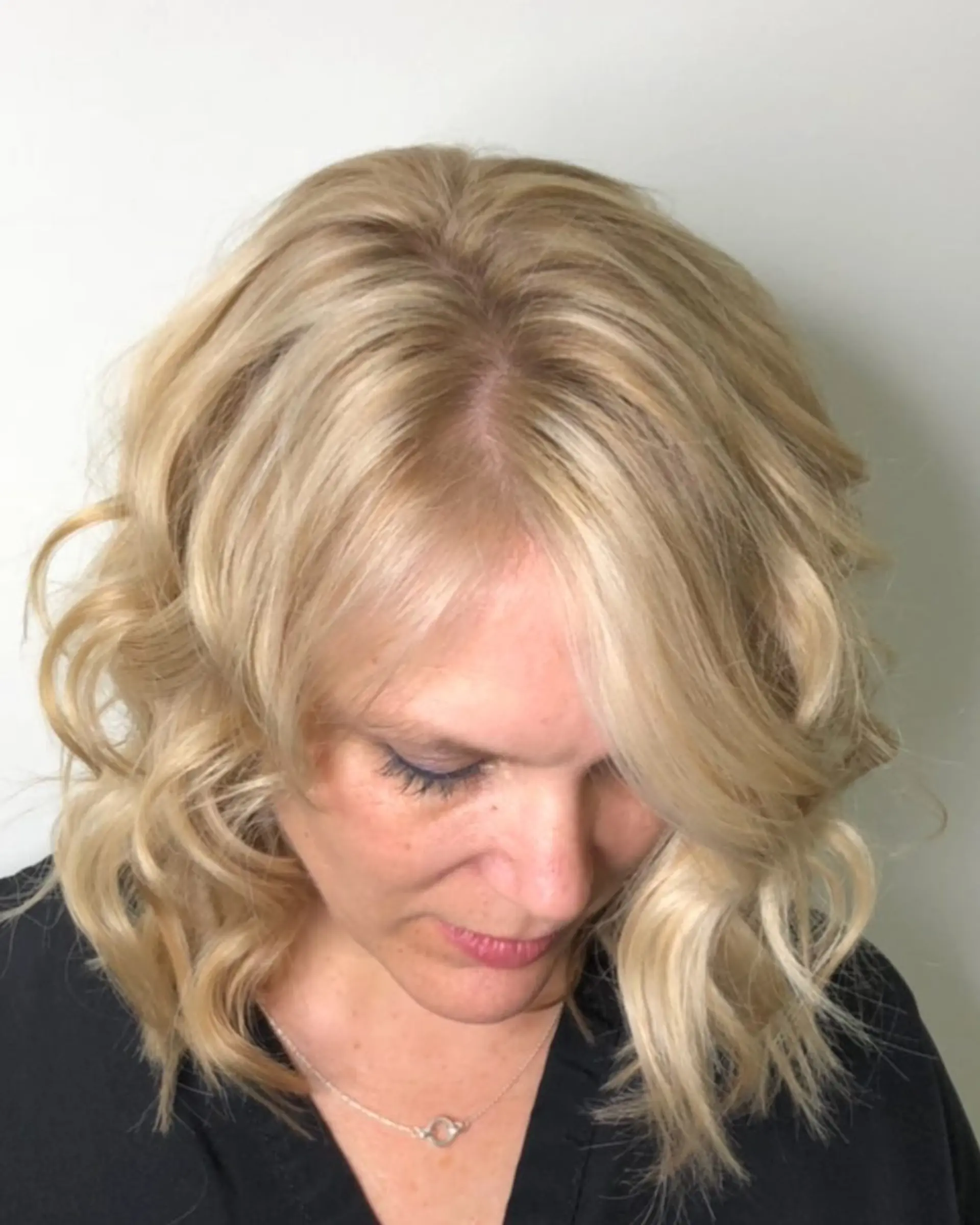 Shoulder-length lob styled with loose, dimensional blonde waves and subtle root depth. 1