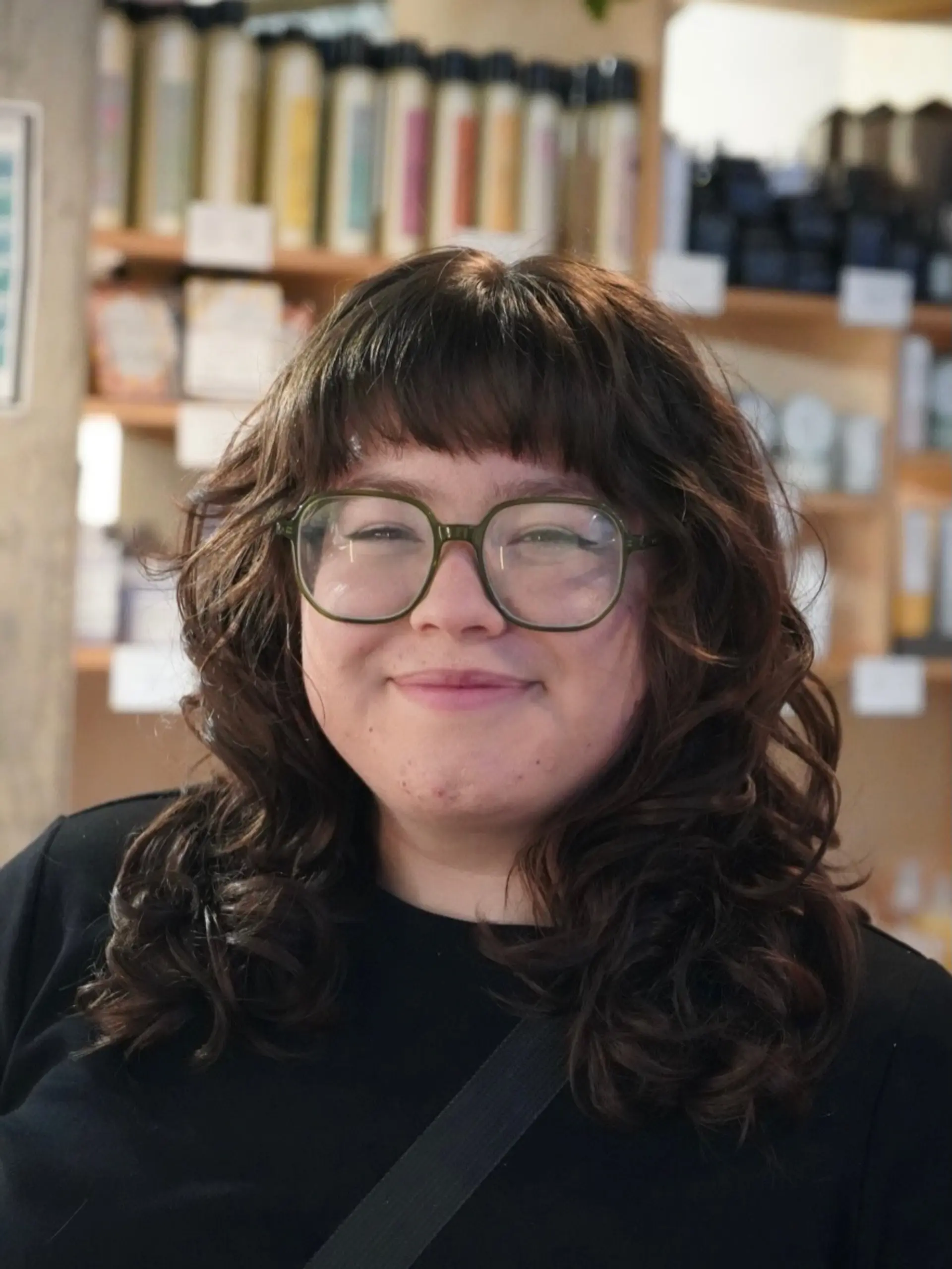 A layered modern shag cut featuring piecey brow-length bangs, heavy texture, and soft cascading curls and waves framing the face. 1