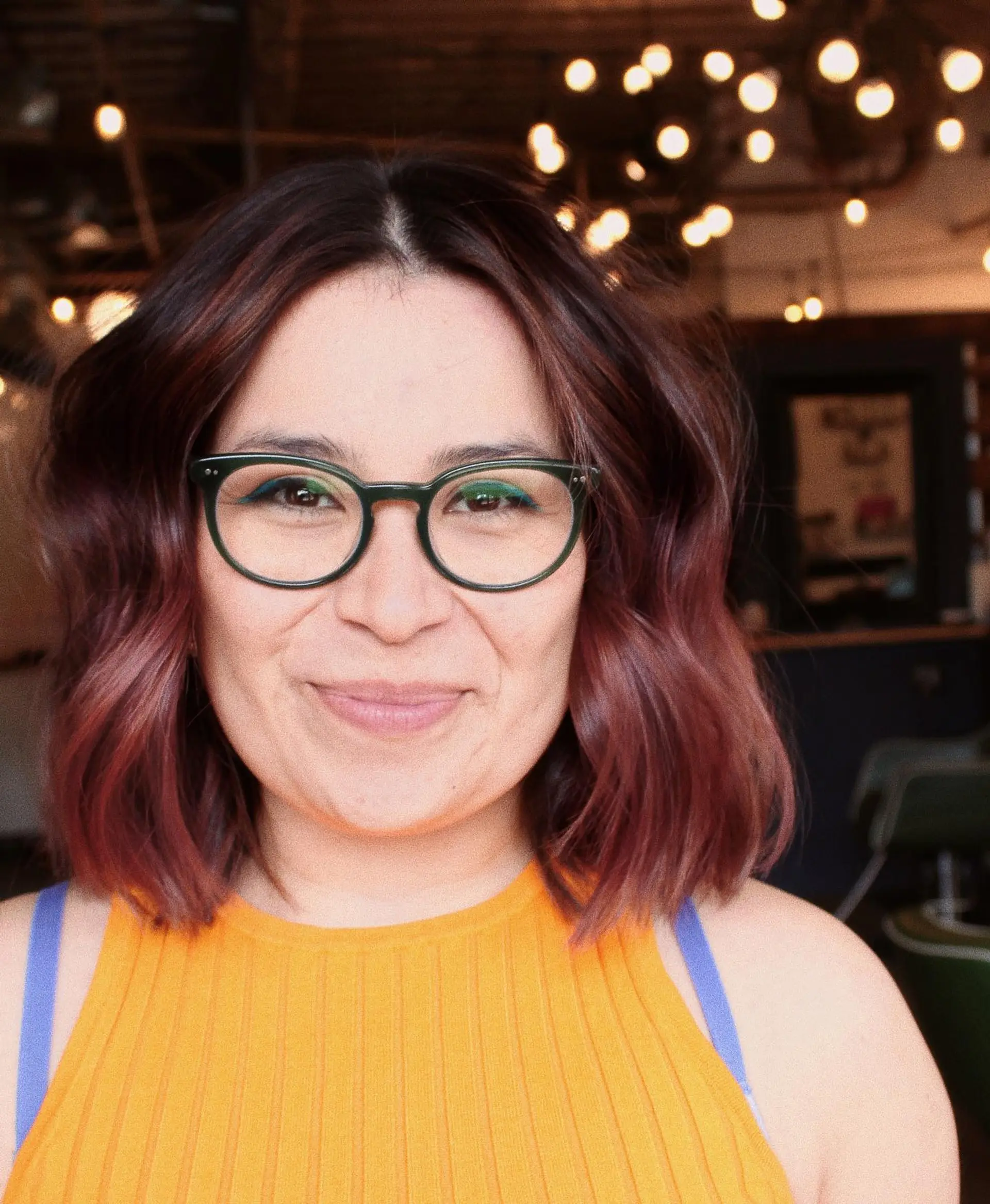 A textured bob styled with loose, relaxed waves, featuring a dark root melting into soft rose-mauve tones. 1