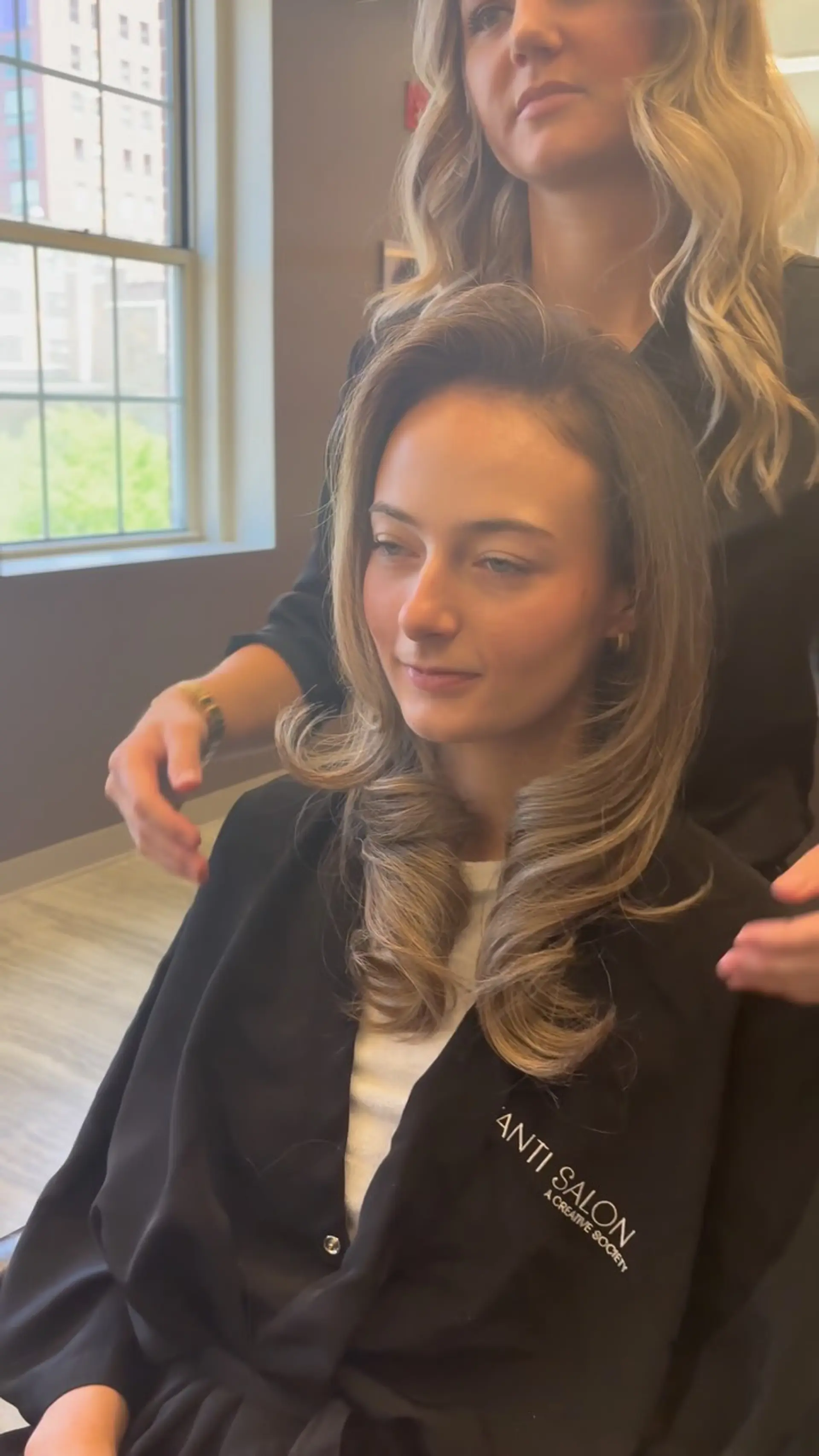 A voluminous, polished blowout featuring smooth face-framing layers and soft, curled ends. 1
