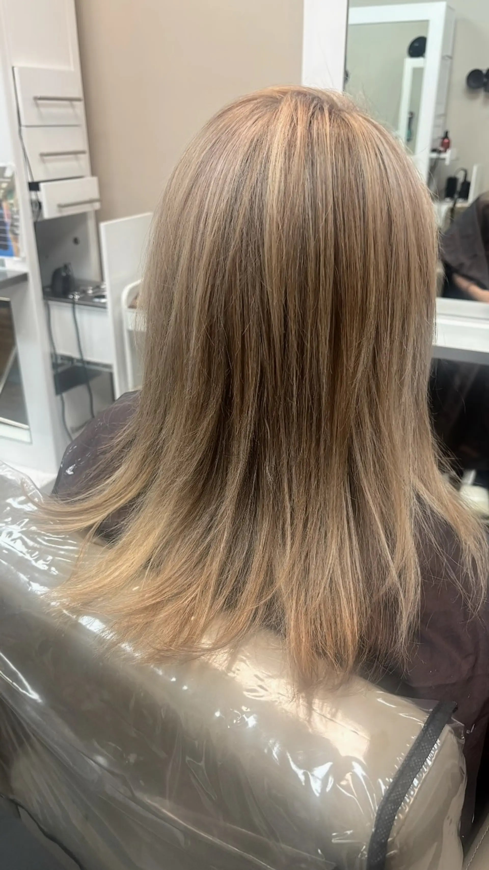 Straight, medium-length warm honey blonde hair styled smooth with natural movement. 1