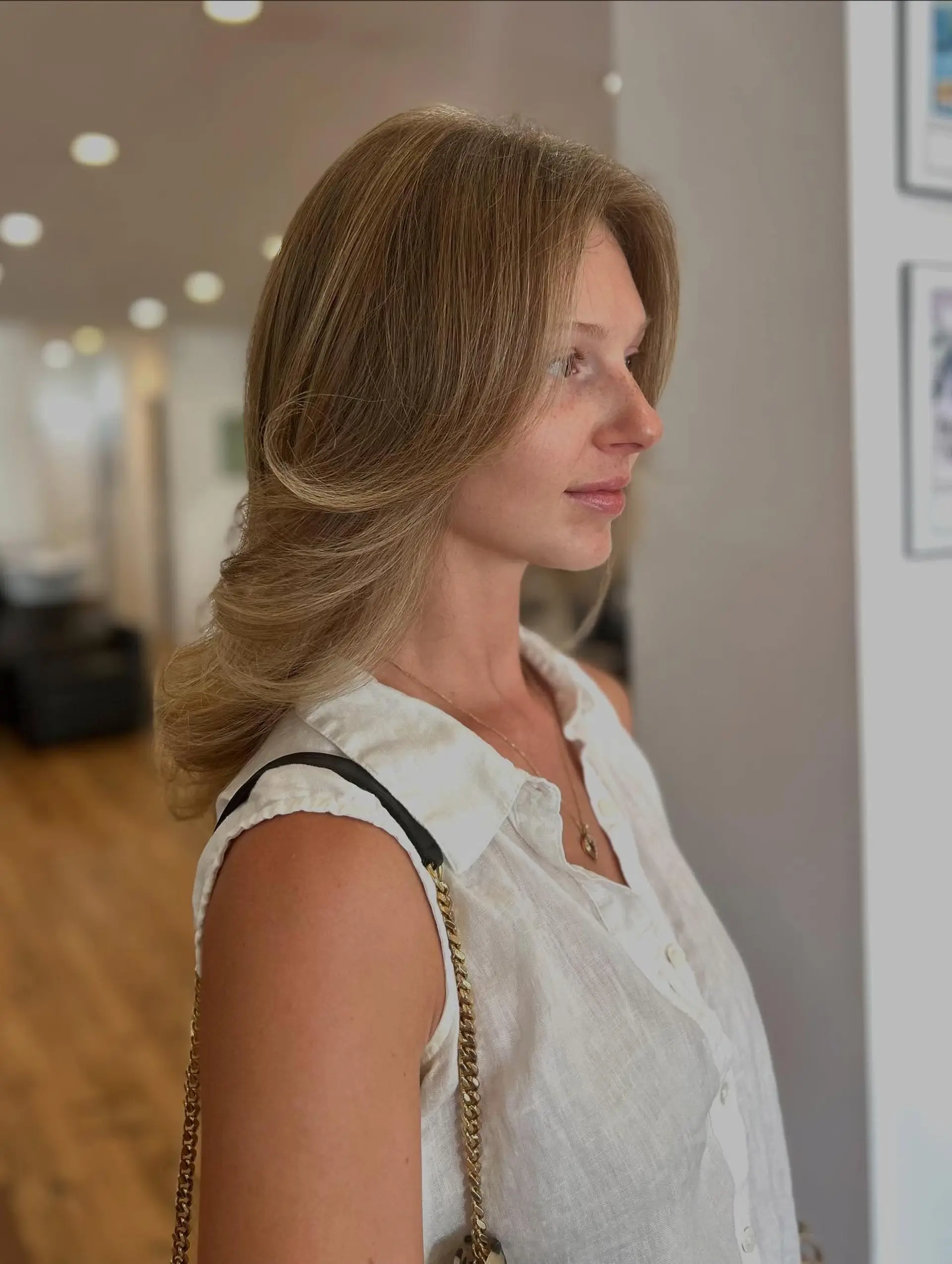 A medium-length layered haircut styled into a 90s blowout with curtain bangs and face-framing layers. 2