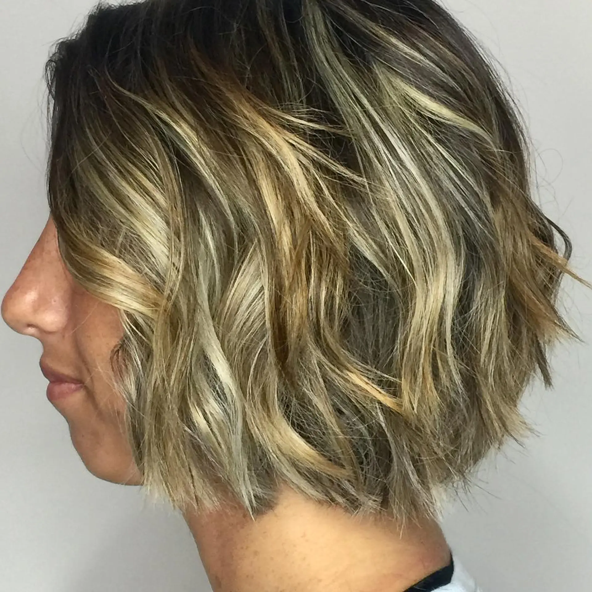 A short, wavy bob with blonde highlights. 1