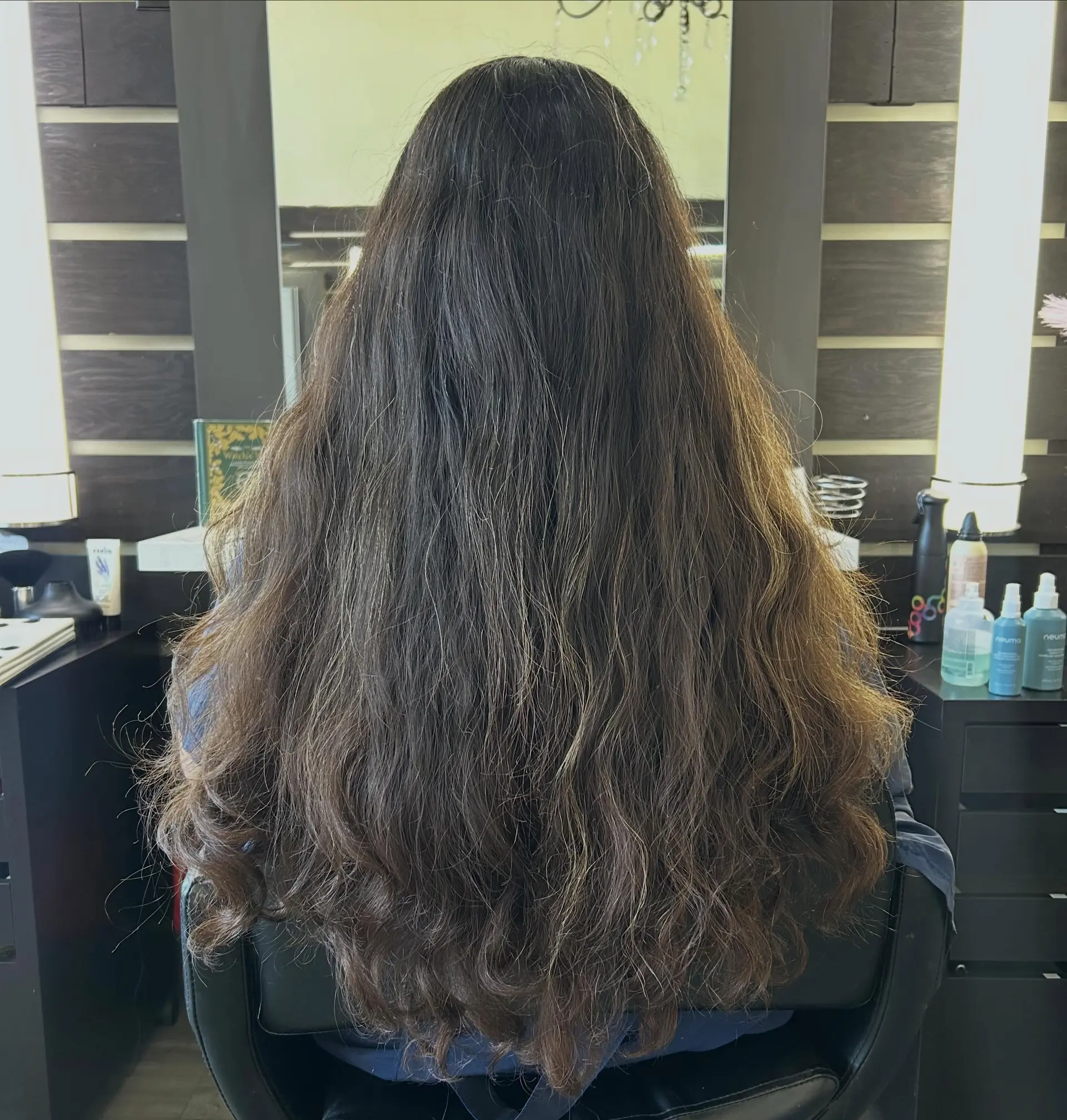 Extra long dark brown hair styled with voluminous textured layers and soft natural waves falling down the back. 1