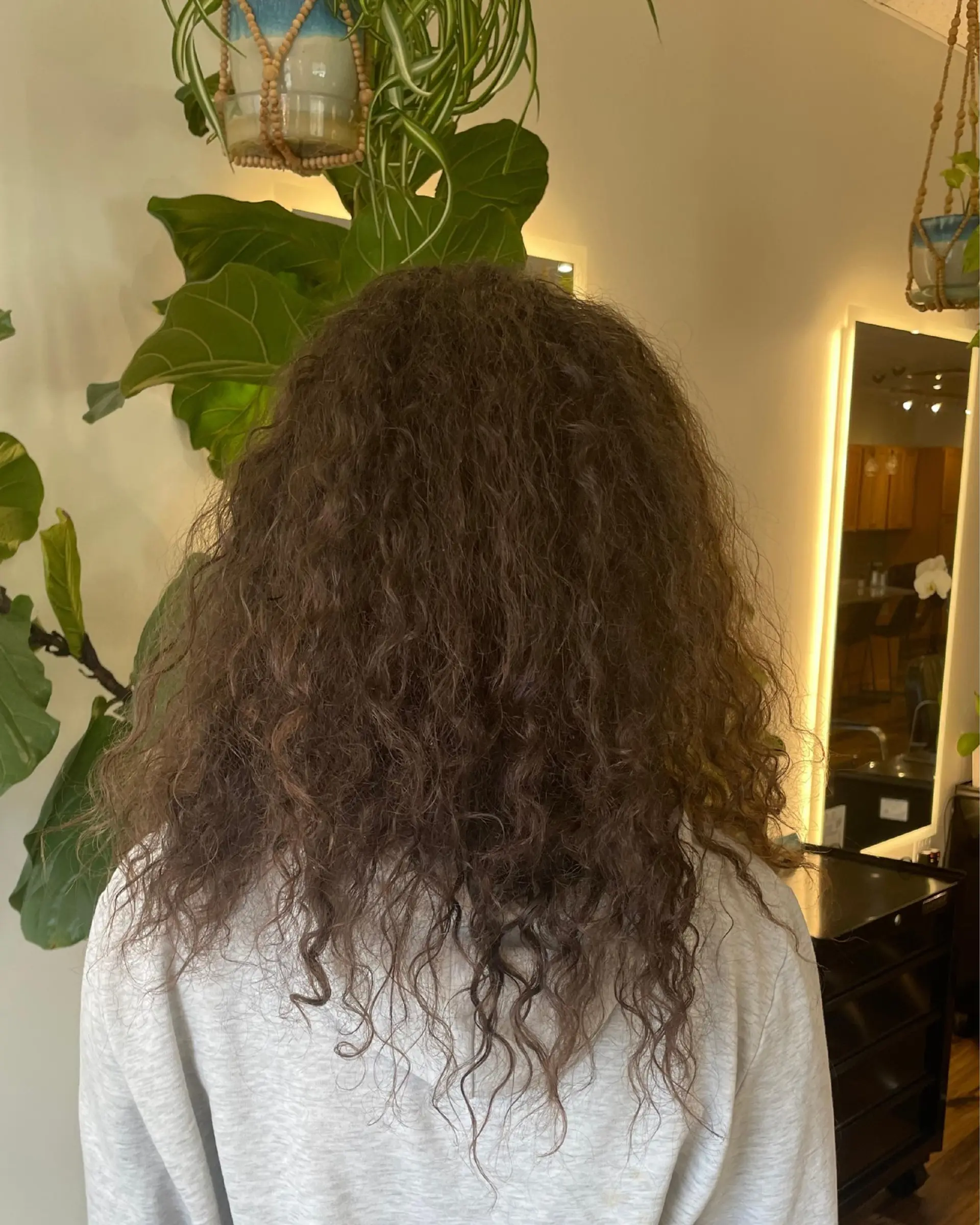 Long, textured curly haircut with soft layers designed to maximize natural curl volume and shape. 1