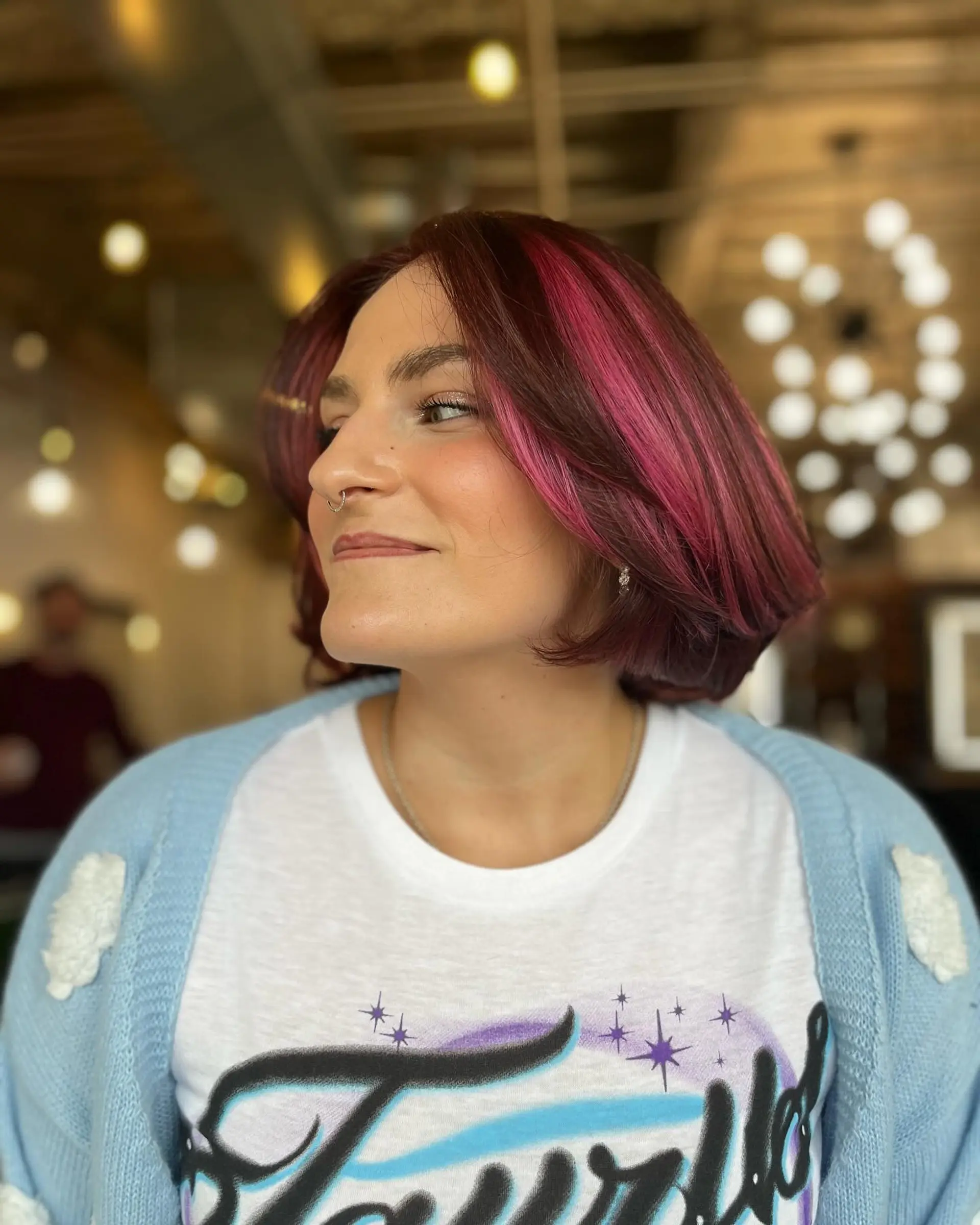 A voluminous chin-length bob with soft, turned-in ends and bold magenta and pink face-framing highlights over a deep reddish-brown base. 1