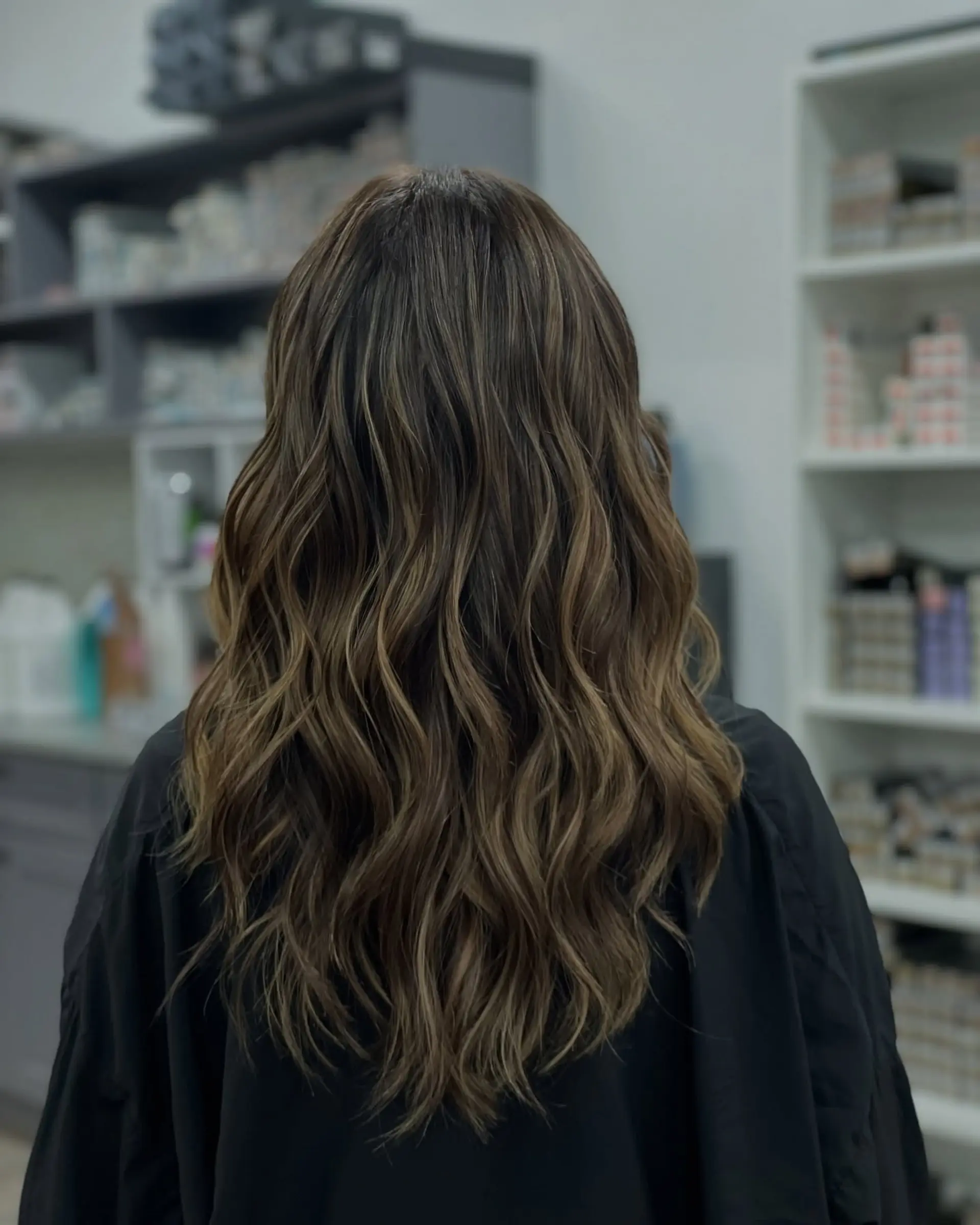 Long layered wavy hair with dimensional highlights. 1