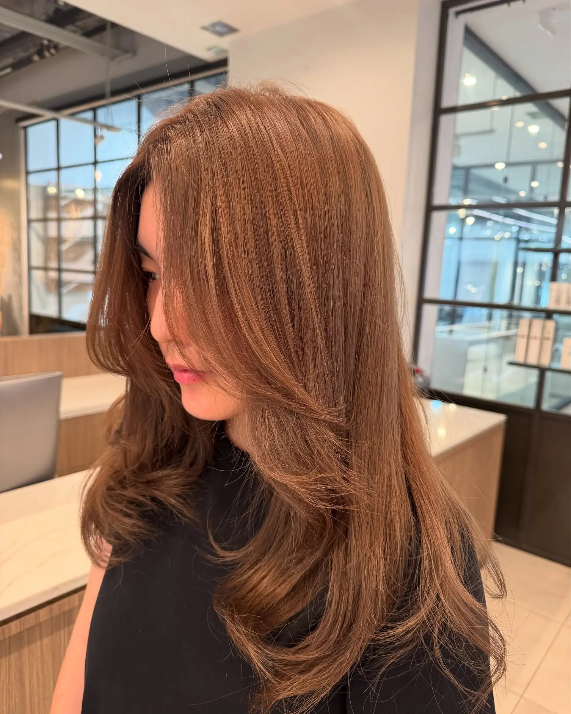 The style features layers throughout the hair, giving it movement and volume. It's finished with a smooth blowout, perfect for adding a touch of elegance. 1