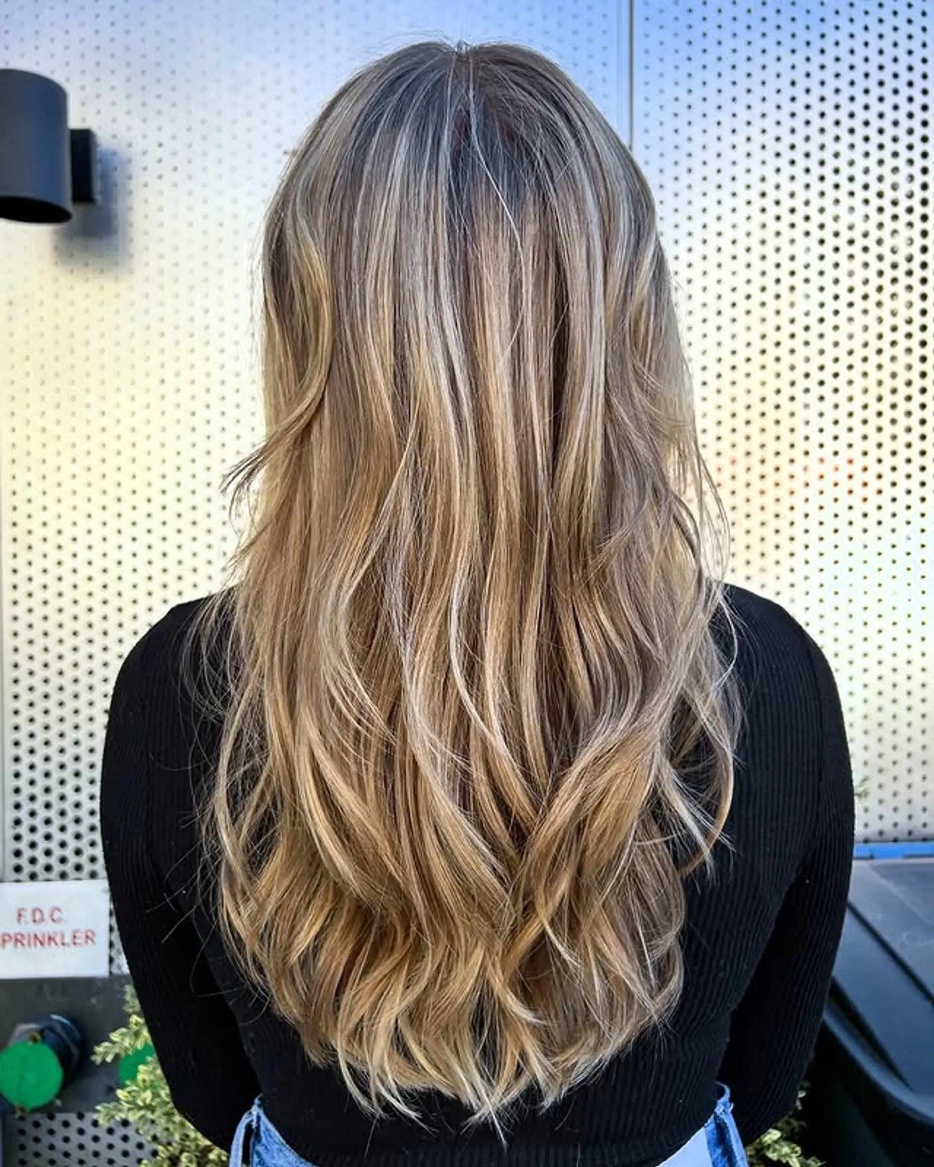 Long, layered wavy hair with a buttery blonde balayage. 1