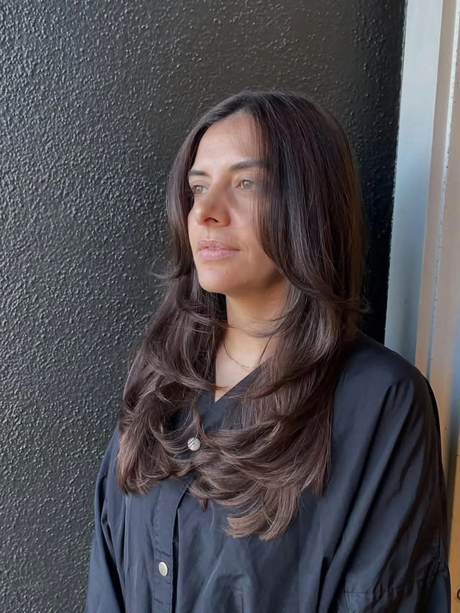 A long layered hairstyle with curtain bangs and face-framing layers. 1