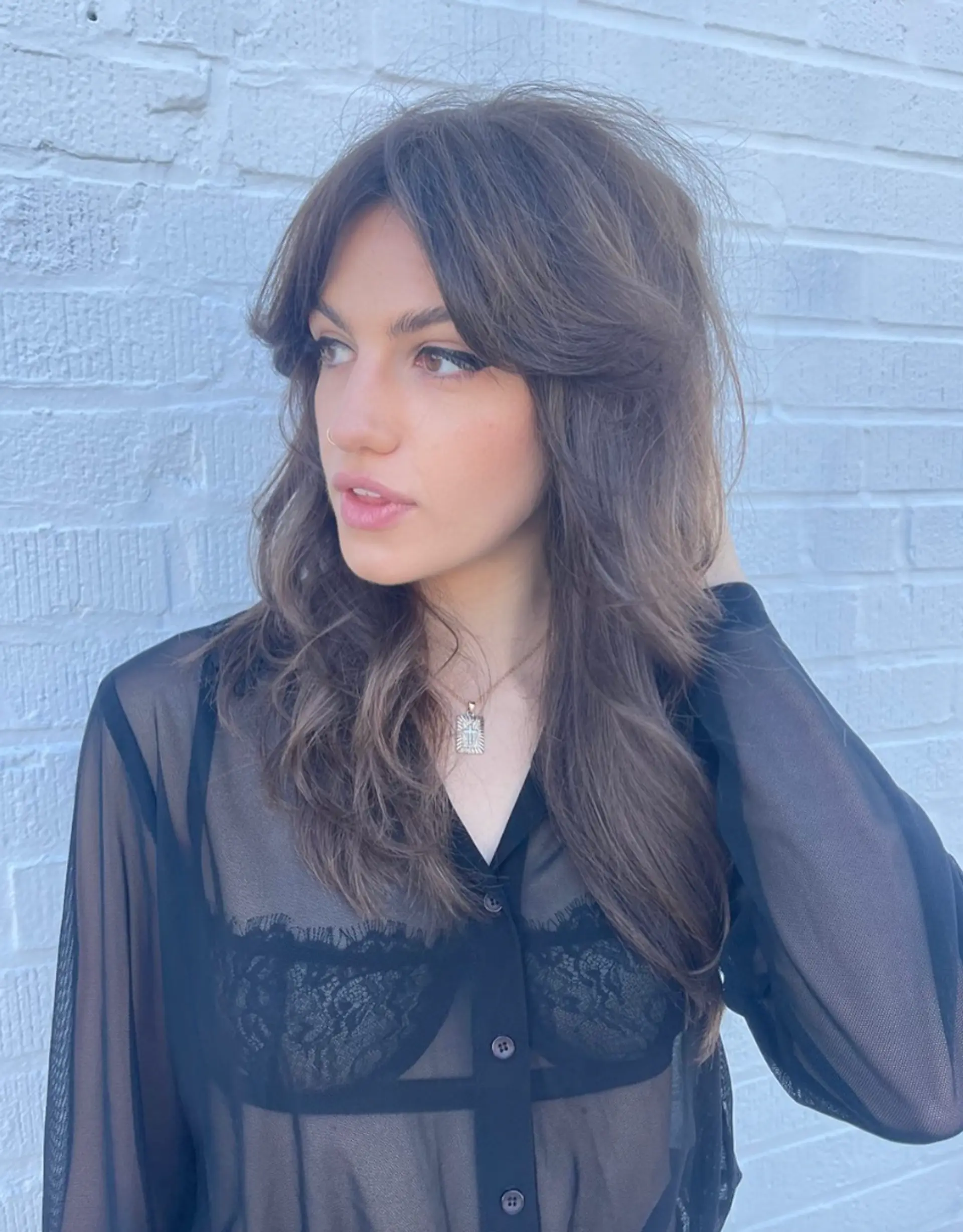 Long, wavy, and naturally flowing waves with chestnut brown color and subtle highlights. The layered cut adds volume at the crown, complemented by a side part for a casual yet elegant look. 1