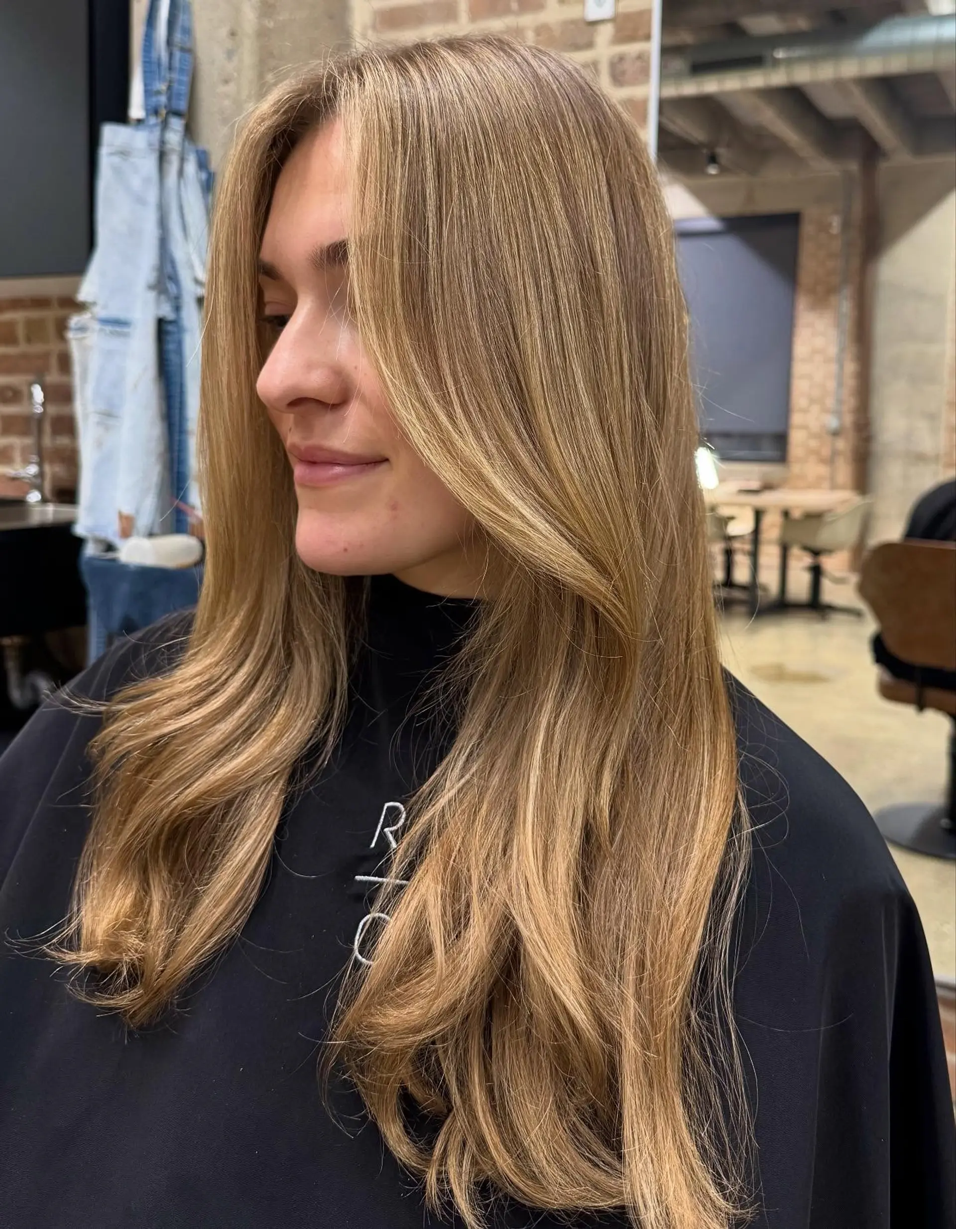 A modern long haircut with face-framing layers and soft, sweeping curtain bangs, creating movement and volume. 2