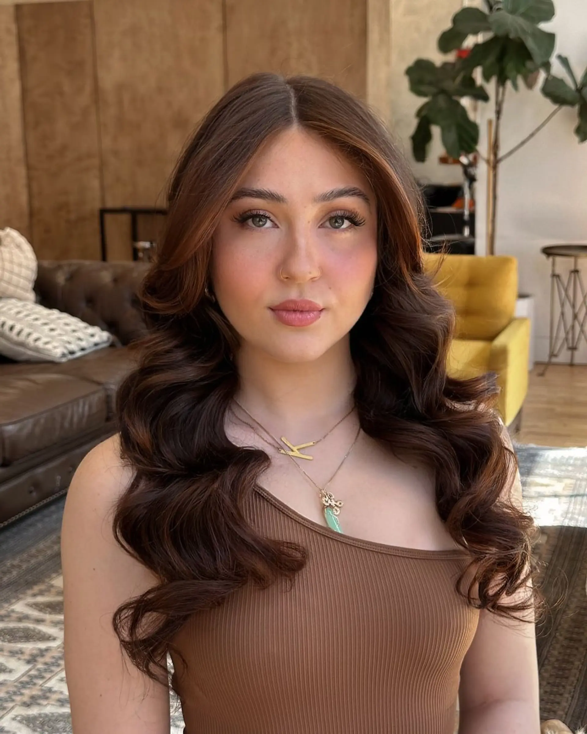 Long, wavy brown locks with a middle part, featuring loose and voluminous waves that provide a natural and lustrous shine.
@alexisfosterartistry of KINHOUSE.
 2