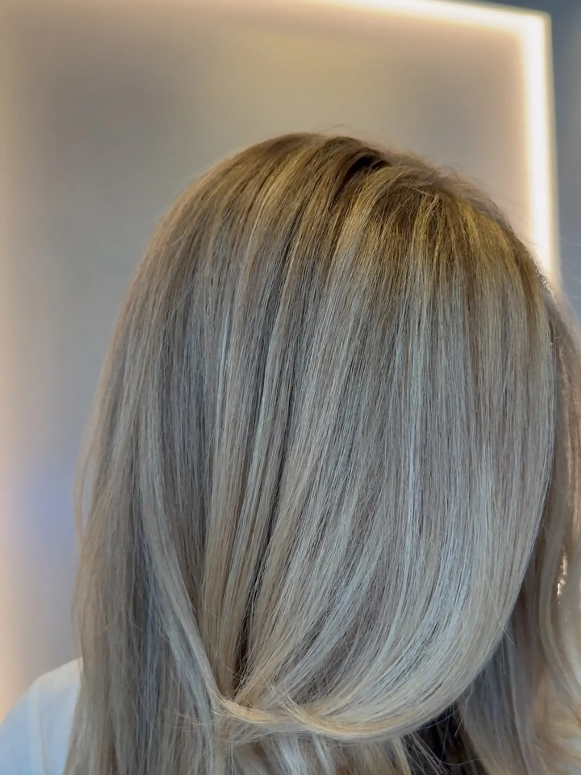 A creamy butter blonde color with fine multidimensional highlights styled smooth with a subtle bevel. 1