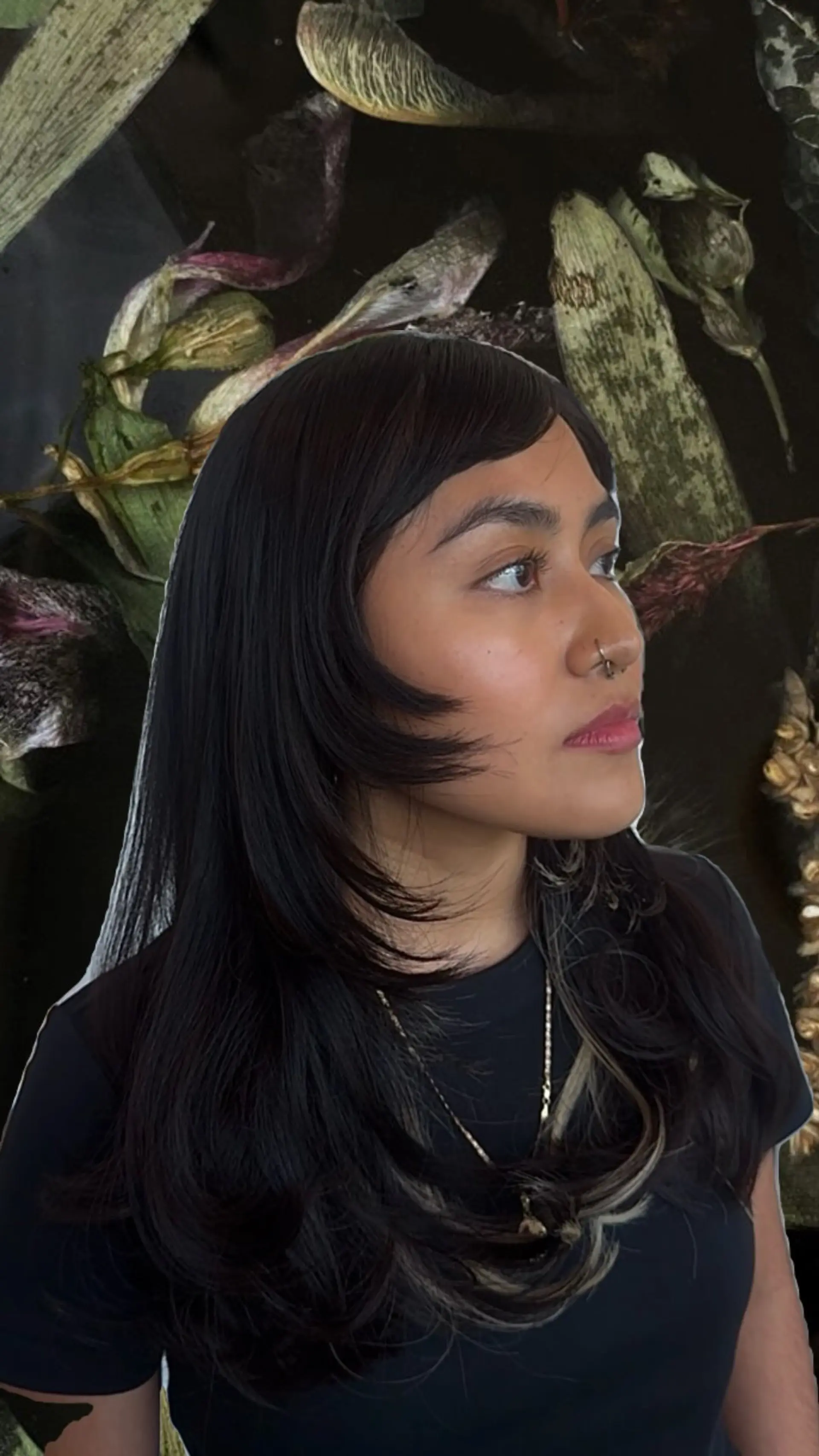 Long dark layered haircut featuring side-swept fringe and subtle blonde peekaboo highlights underneath. 1