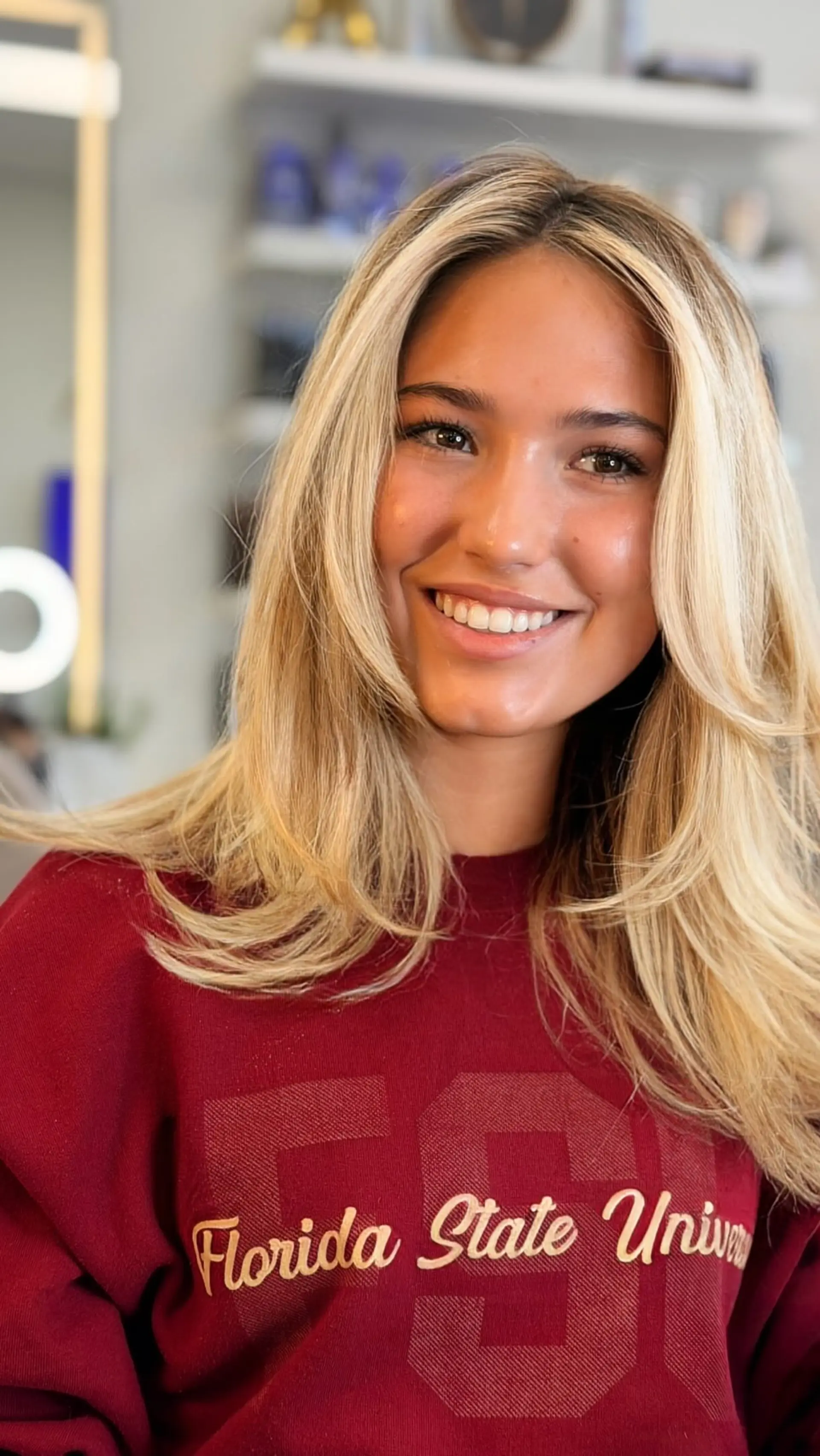 A bright blonde blowout featuring soft, face-framing layers and curved ends. 1