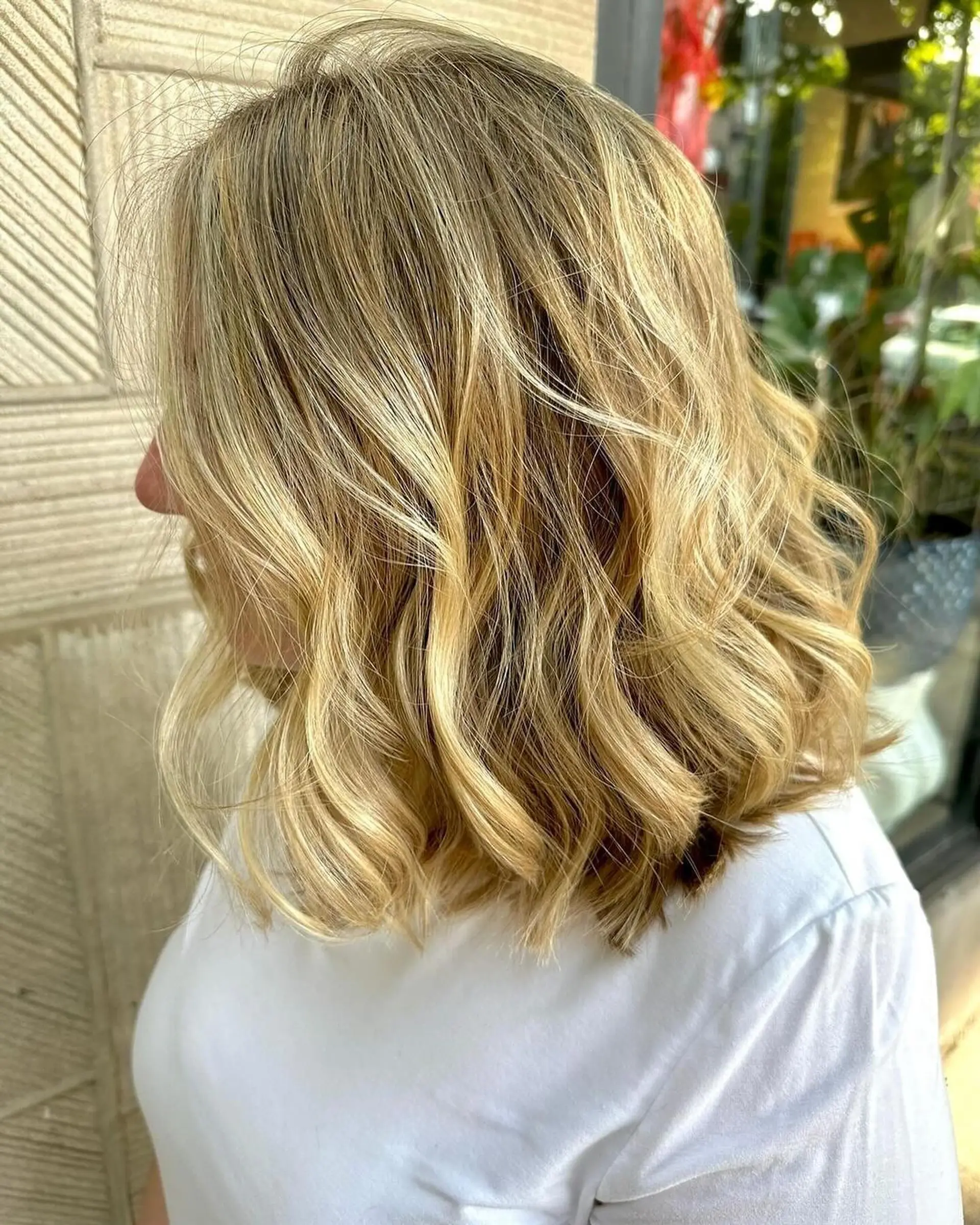 A shoulder-length blunt lob styled with loose, effortless waves and bright blonde highlights for dimensional texture. 1