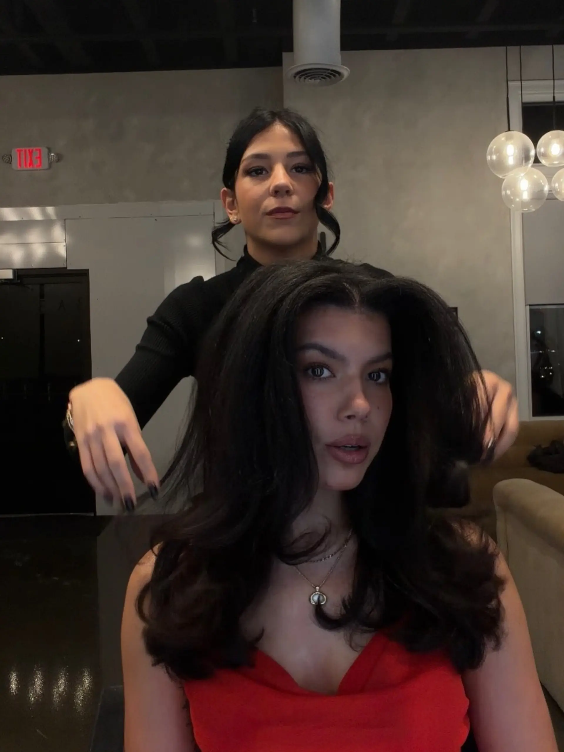 A glamorous, high-volume blowout on long black hair with soft flips and bounce throughout the layers. 1