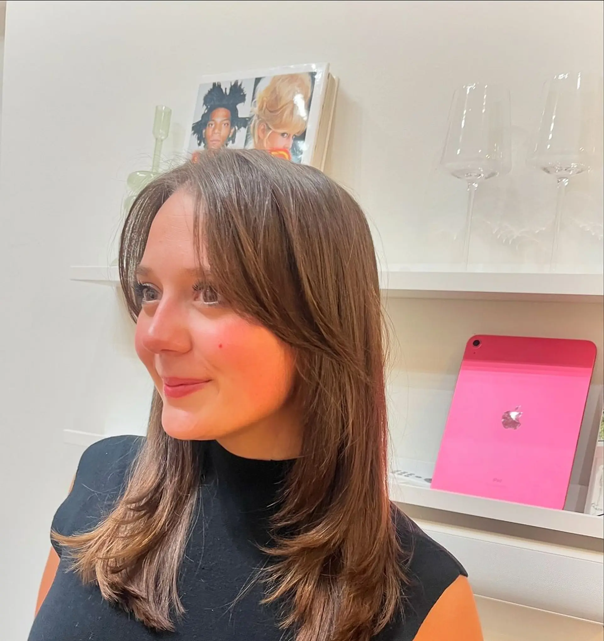 A medium-length straight brown hairstyle with side bangs, feathered and layered ends, creating a polished and chic look. 1