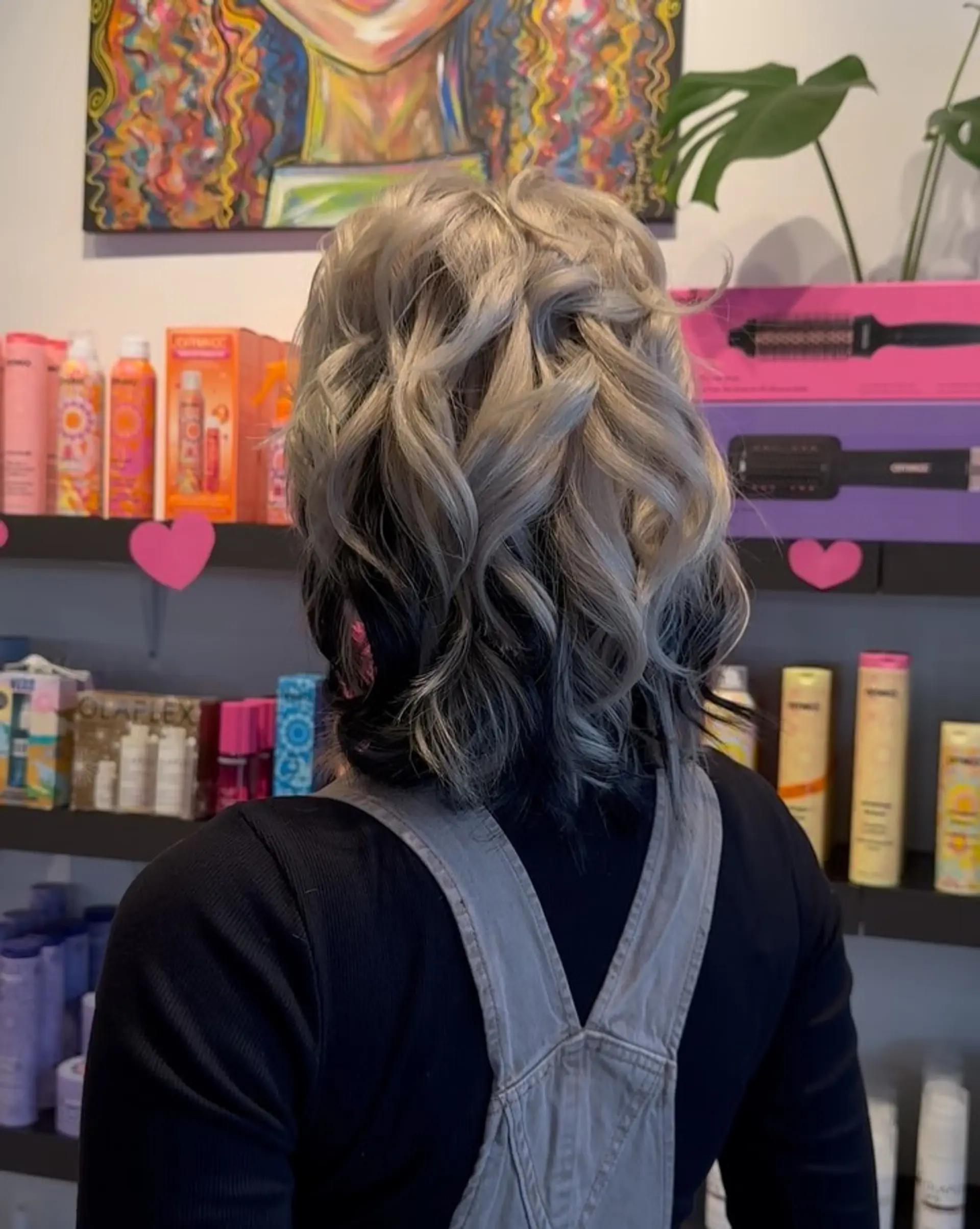 Shoulder-length ash blonde hair styled in voluminous curls with high-contrast black underlayer color. 1