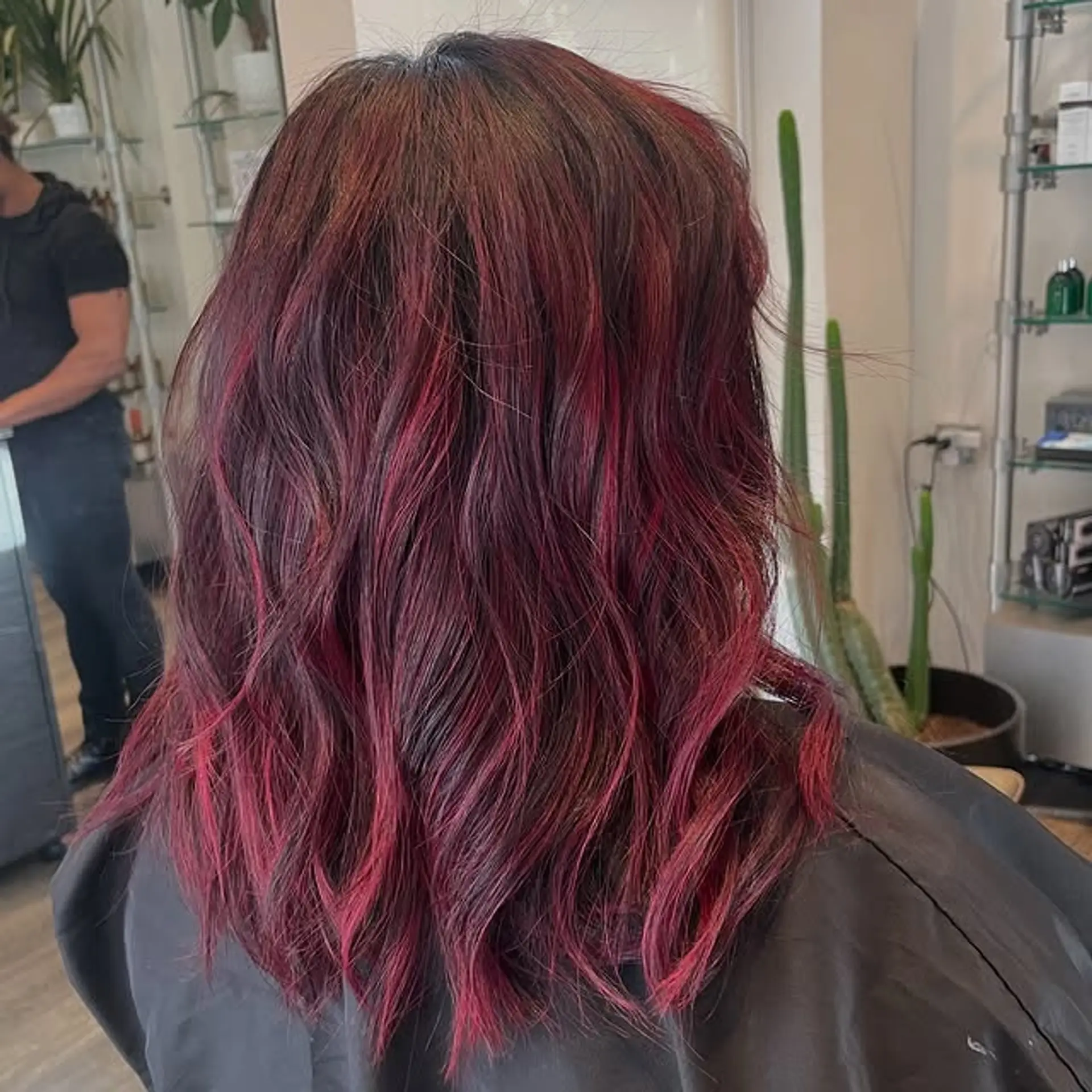 Medium length wavy hairstyle with a mix of burgundy and red tones. 1