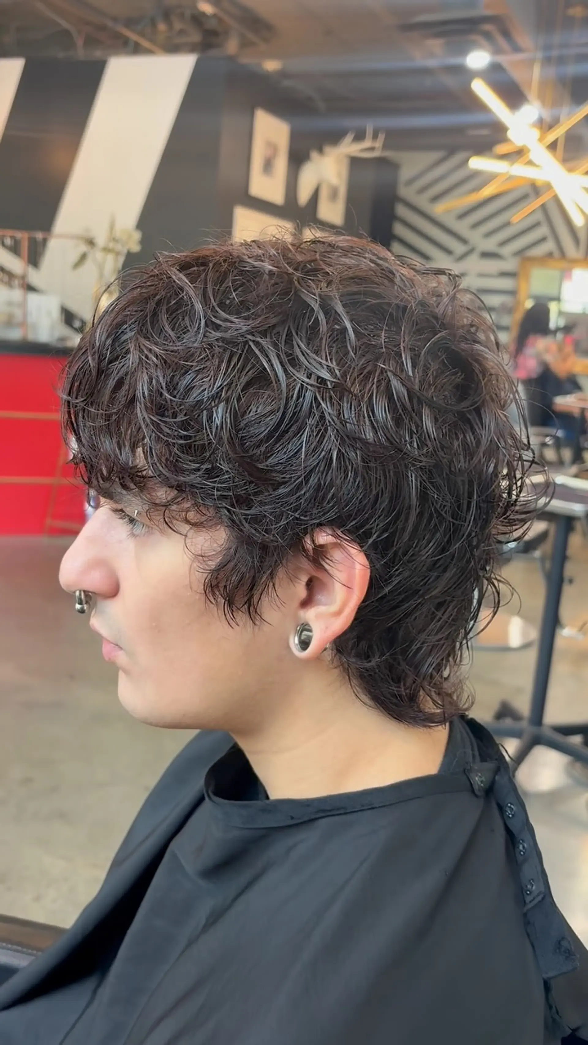 A textured mod-inspired shag haircut with tousled, piecey layers throughout and subtle length extending over the nape and ears. 1