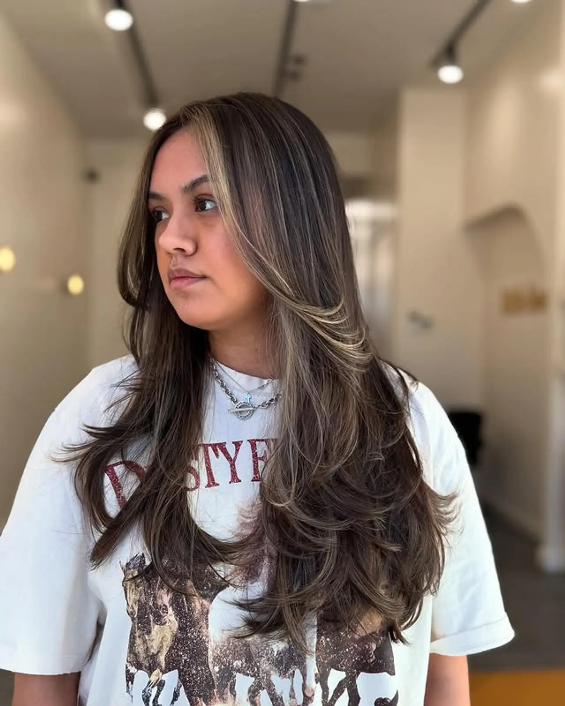 Long, layered wavy hair with face-framing blonde money piece highlights. 1