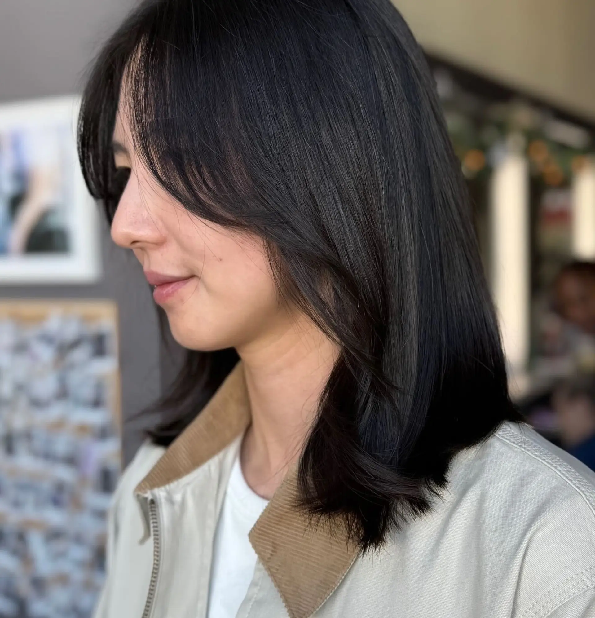 A sleek, collarbone-length dark lob featuring soft face-framing curtain bangs and gently curved ends. 1