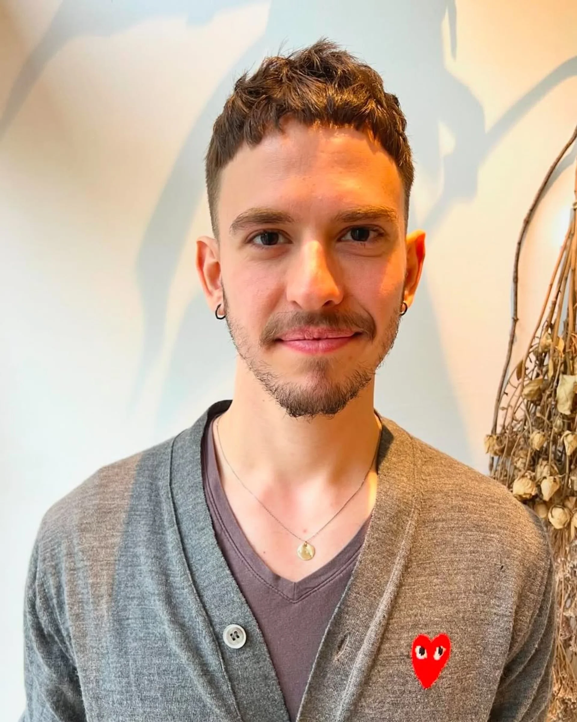 A model with a vibrant red, medium-length bob and sharp blunt bangs, showcasing the 2025 hair trend of Chromatic Courage. - Preview 1