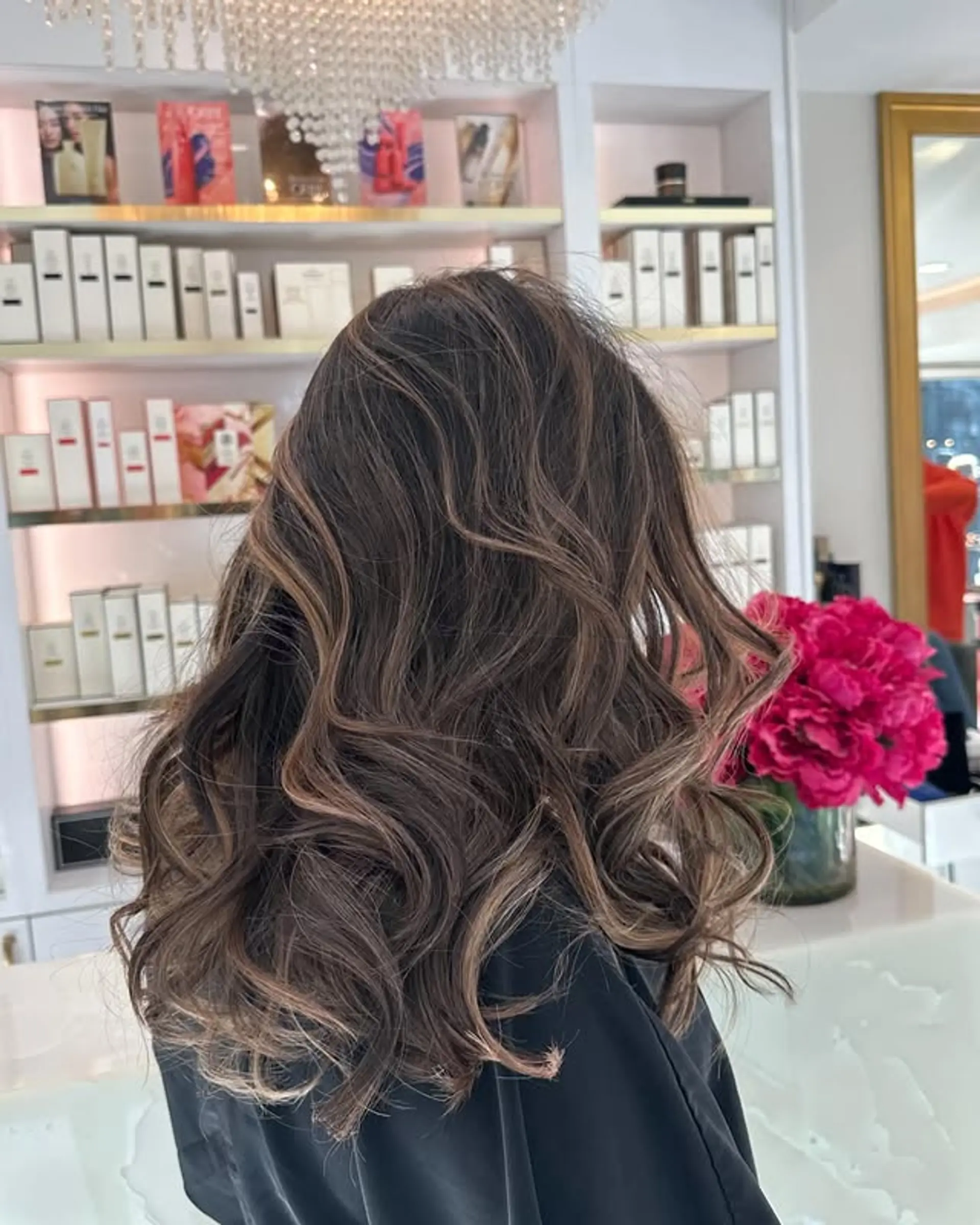 A wavy, medium-length hairstyle with a balayage color technique creating natural-looking beach waves. 1
