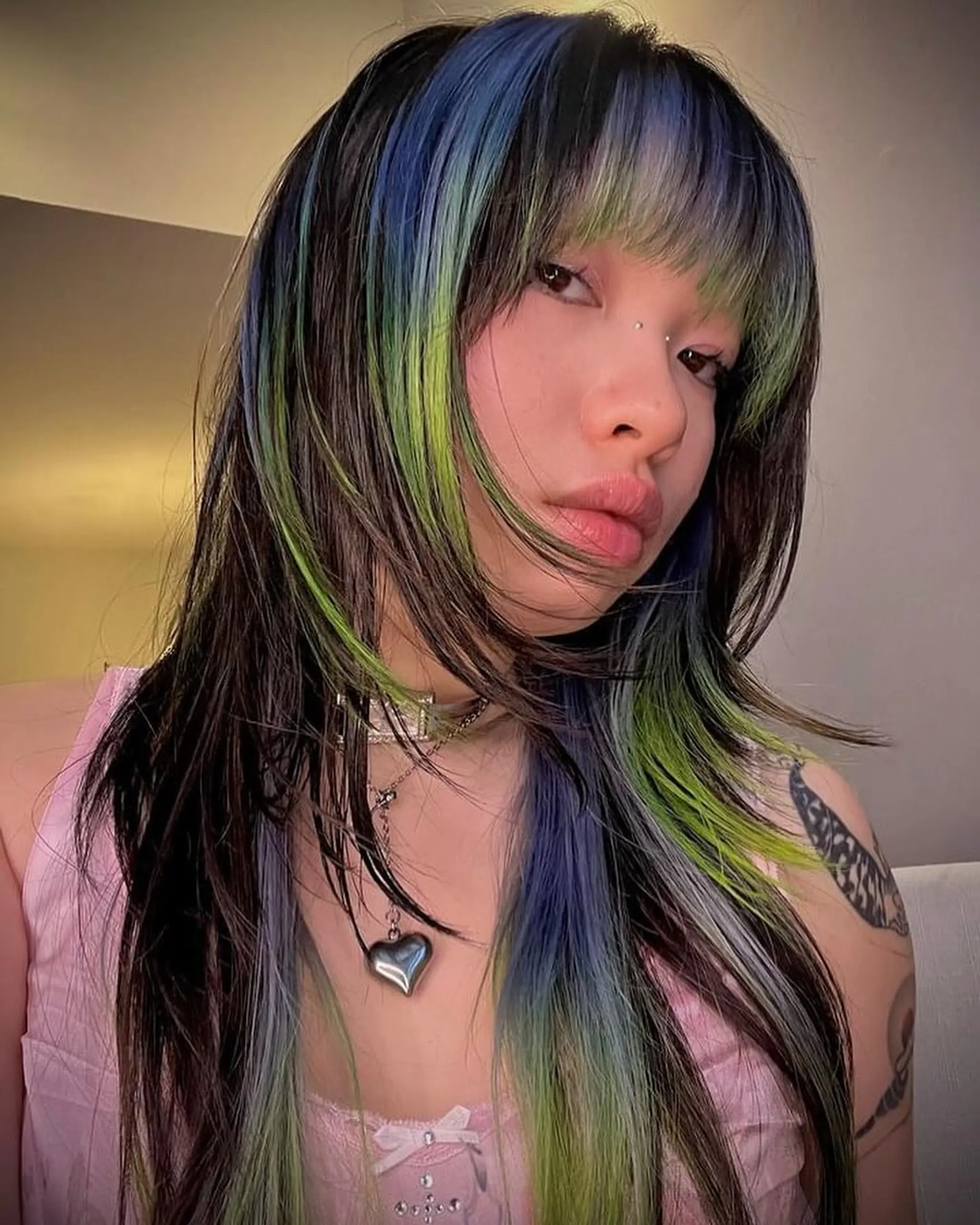 Long, straight hair with vivid black, blue, and green colors, featuring chunky highlights, layered cut, and front bangs.