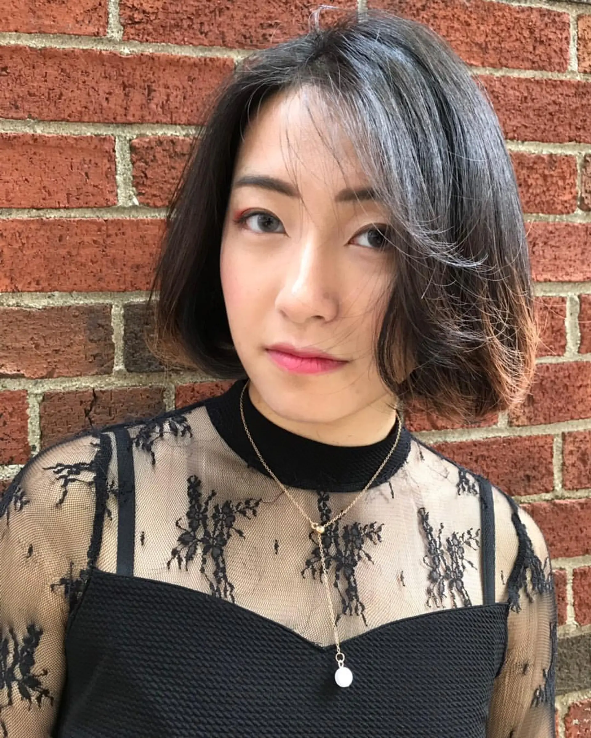 A sleek, medium-length, straight bob with an asymmetrical, side-parted design, featuring a deep, rich black color and a smooth, silky texture. 3