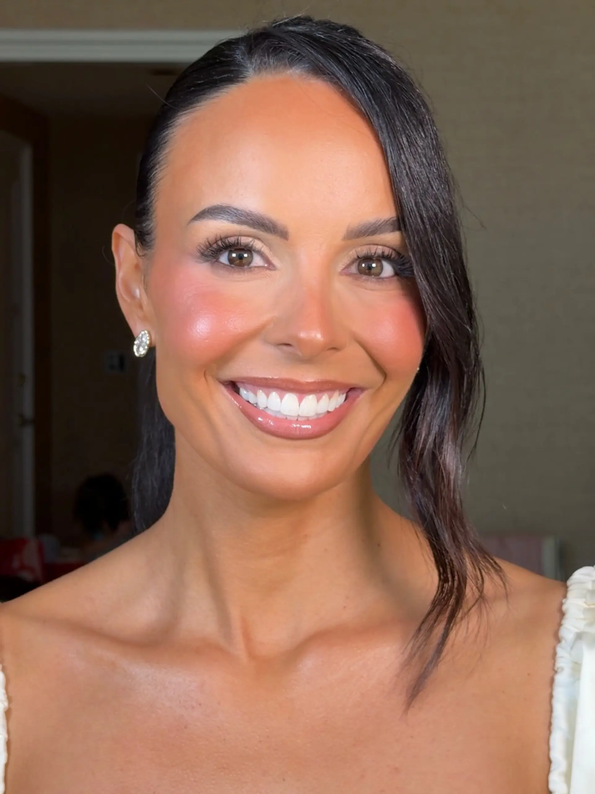 A sleek, polished formal updo featuring a deep side part and a single wavy face-framing tendril. 1