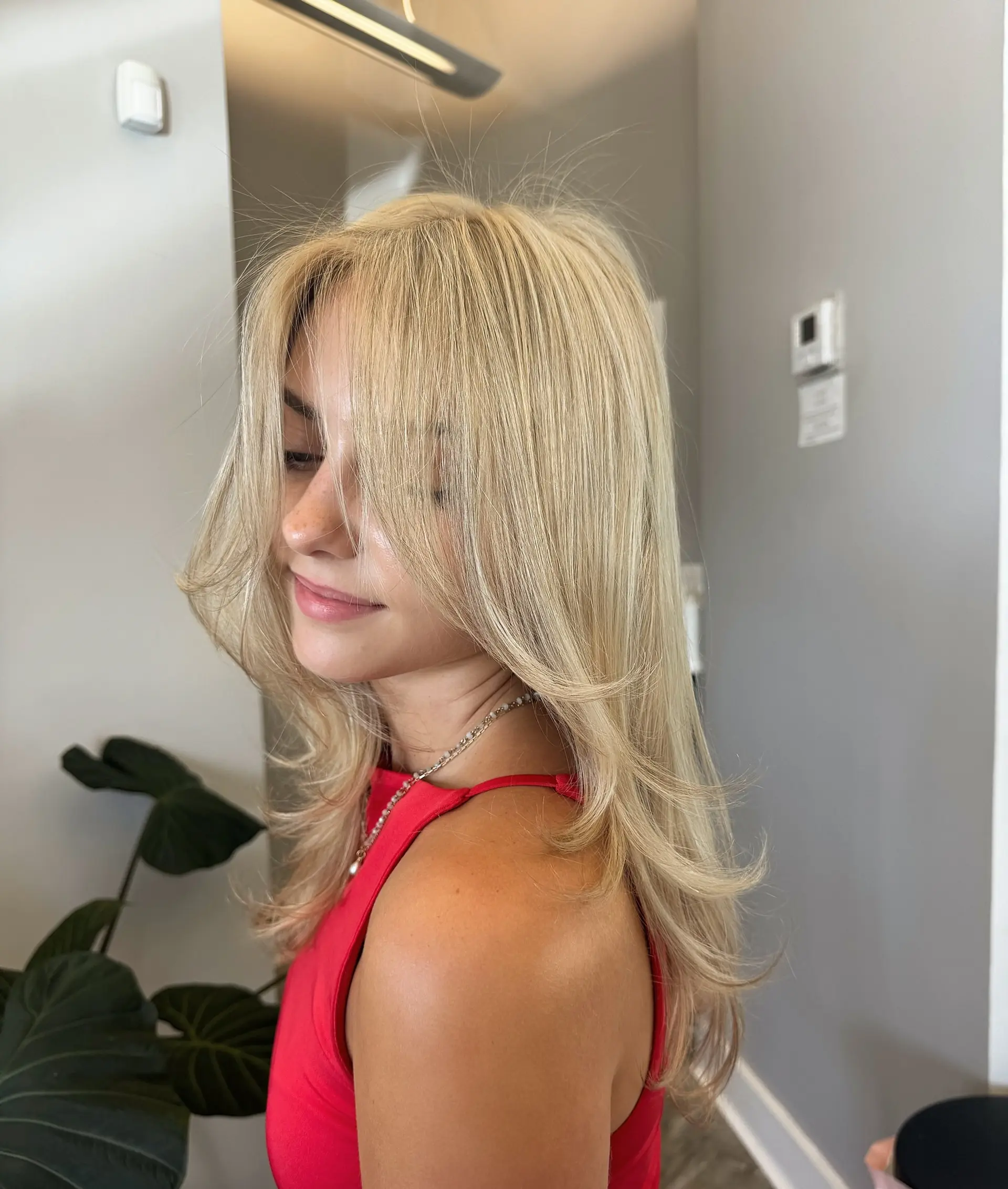 A layered medium-length hairstyle with face-framing layers and curtain bangs. 1