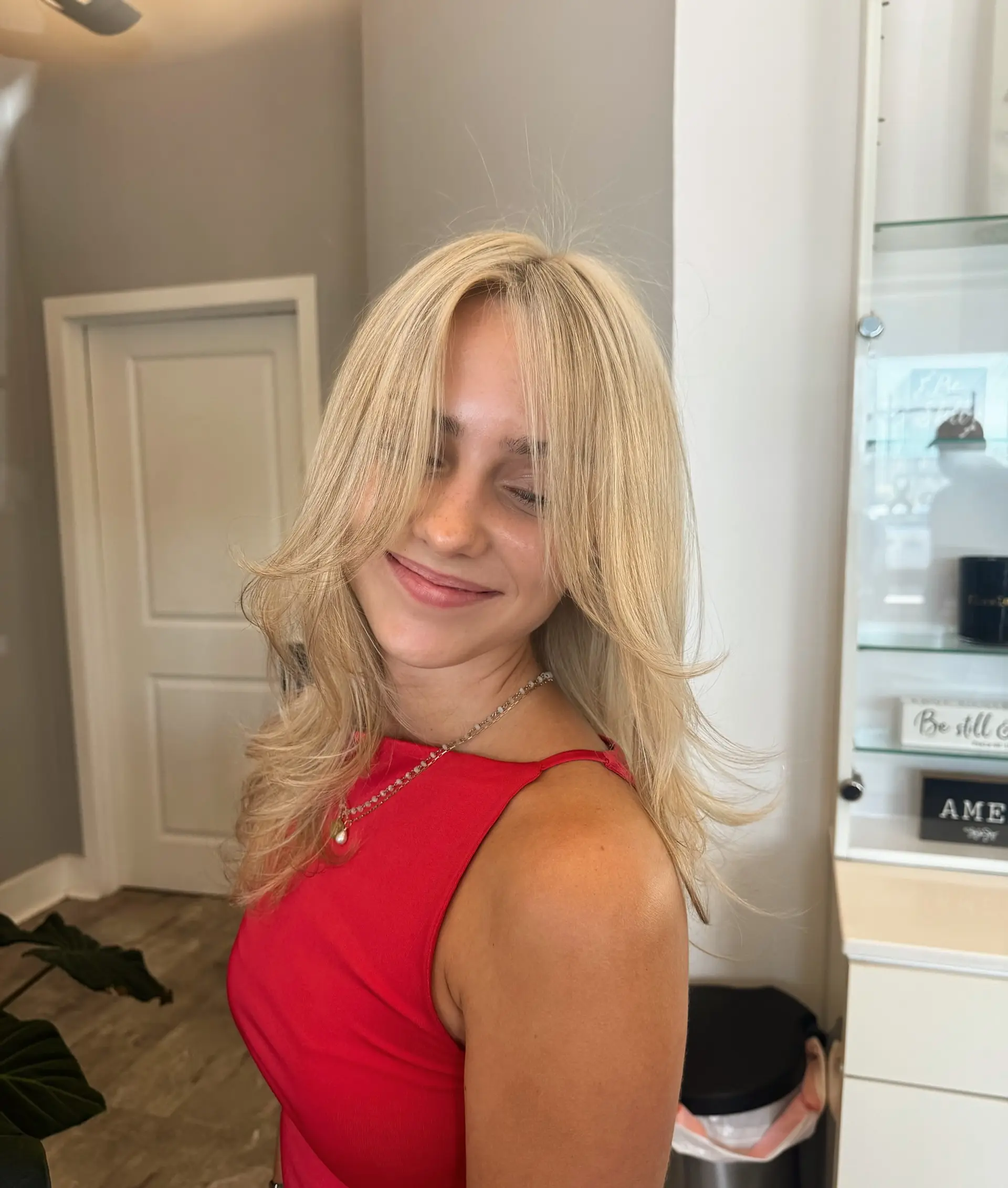 A layered medium-length hairstyle with face-framing layers and curtain bangs. 2