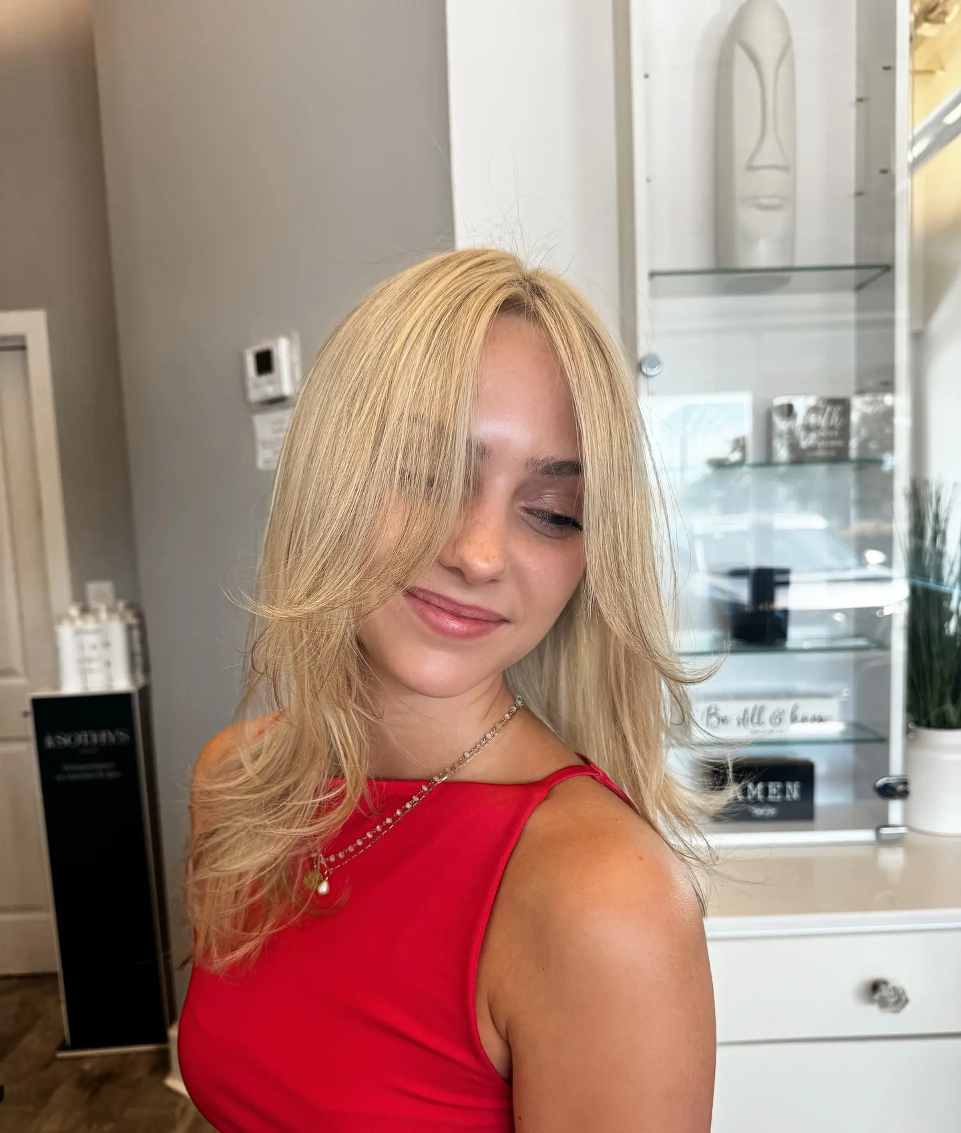 A layered medium-length hairstyle with face-framing layers and curtain bangs. 3