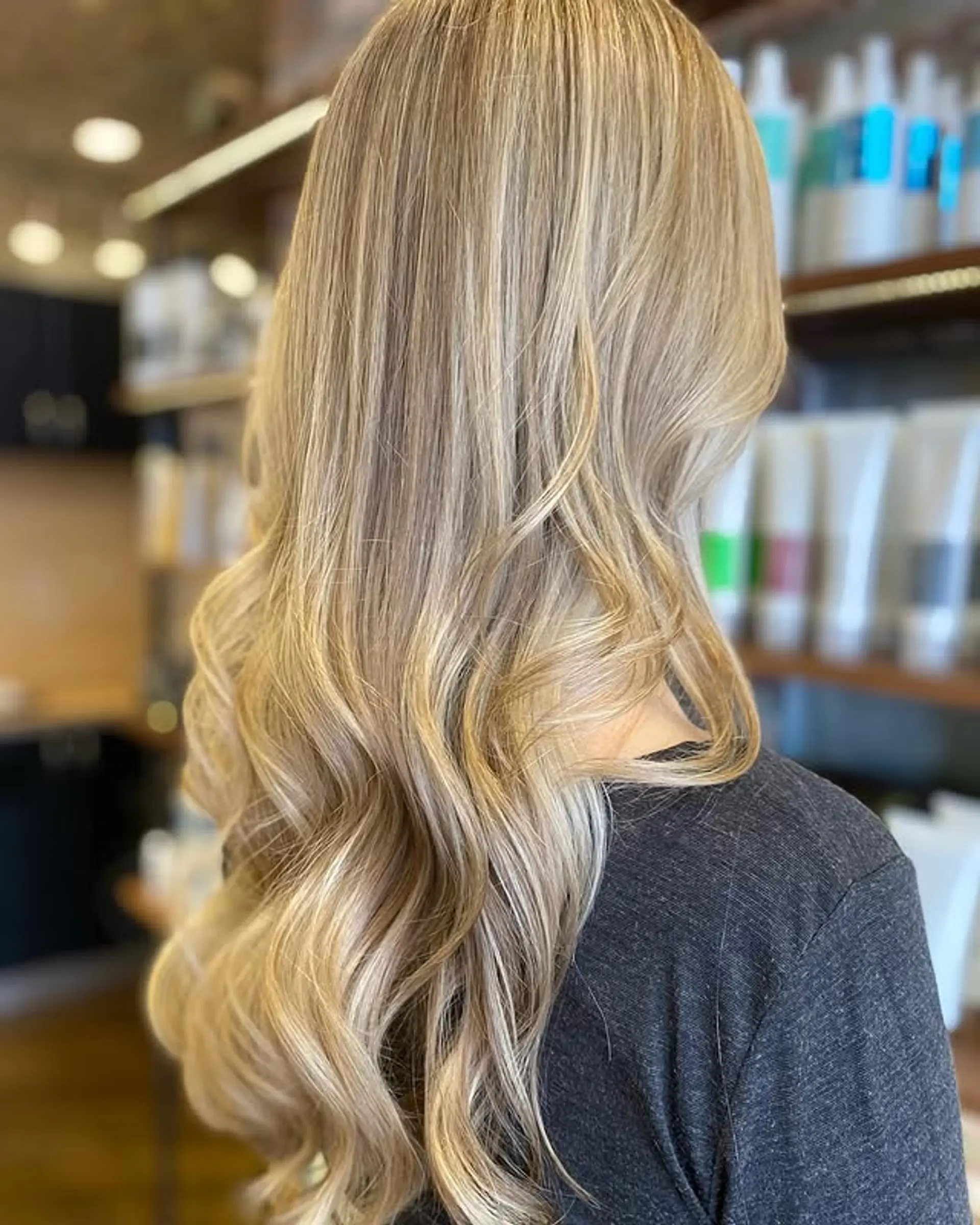 Long, layered wavy hair with a honey blonde balayage. 1
