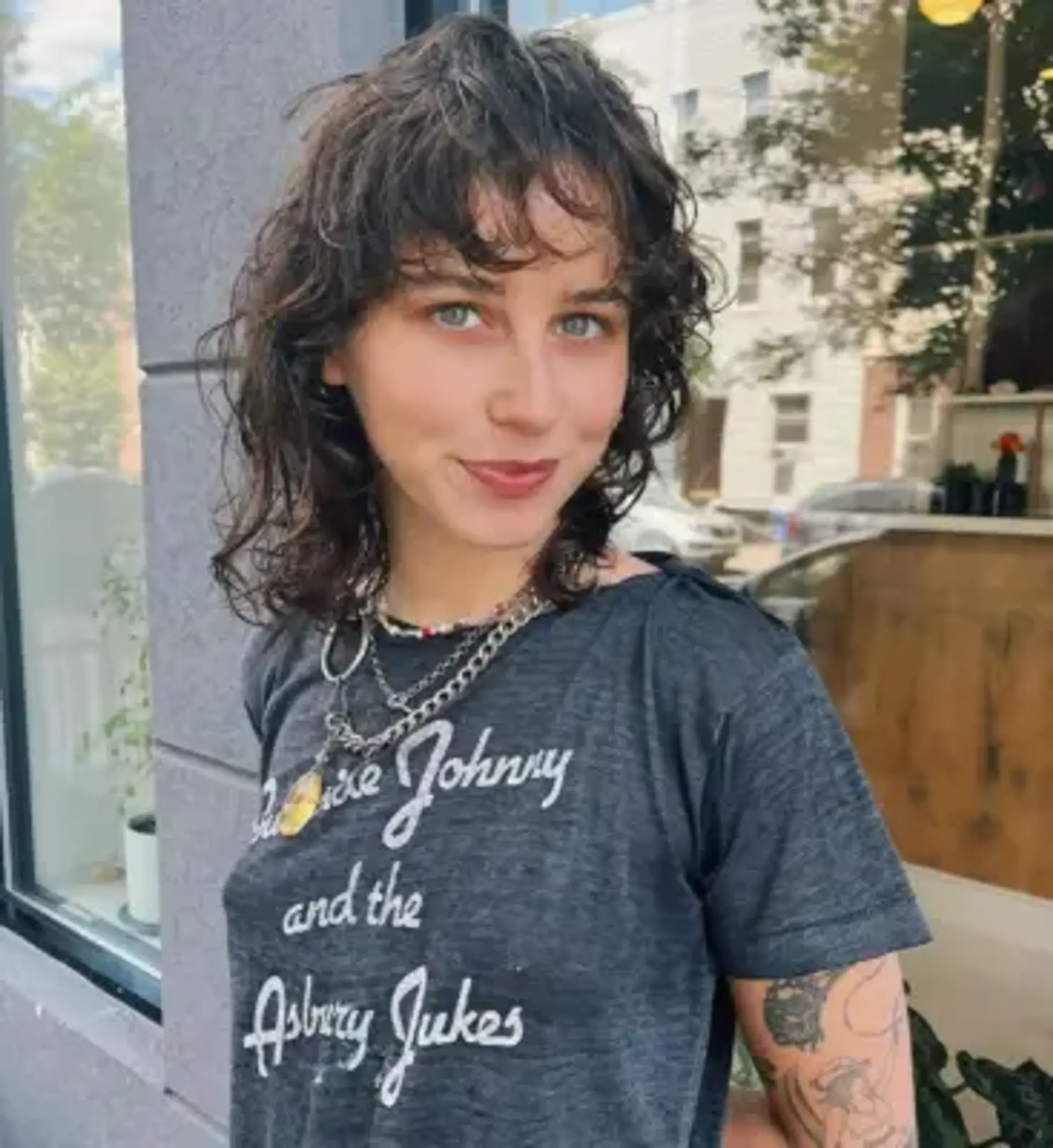 A medium-length, dark brown hairstyle with wavy, shaggy layers and bangs, creating a tousled, relaxed appearance. 1