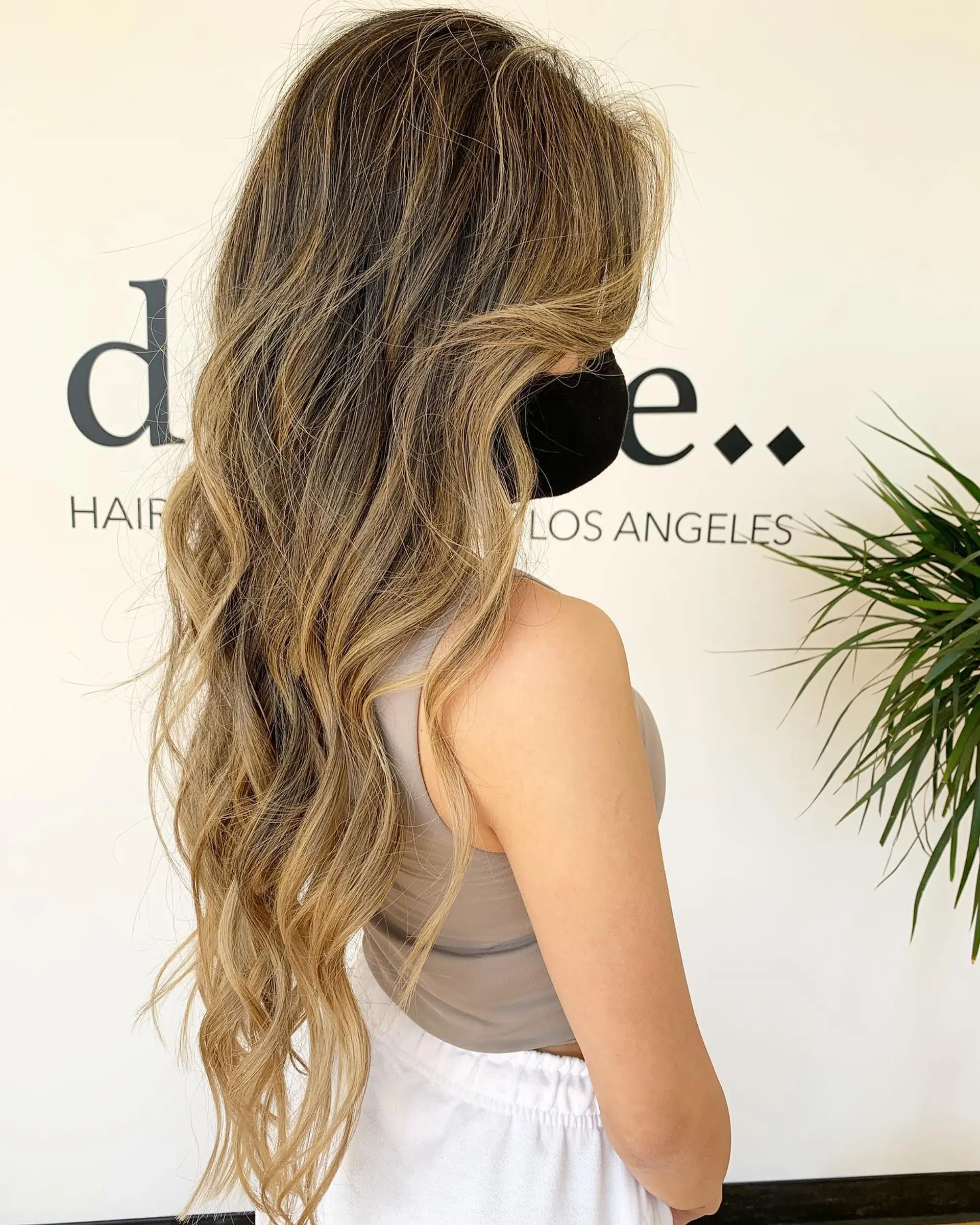 Extra-long layered hair featuring dimensional blonde and caramel highlights styled into soft, flowing beach waves. 1