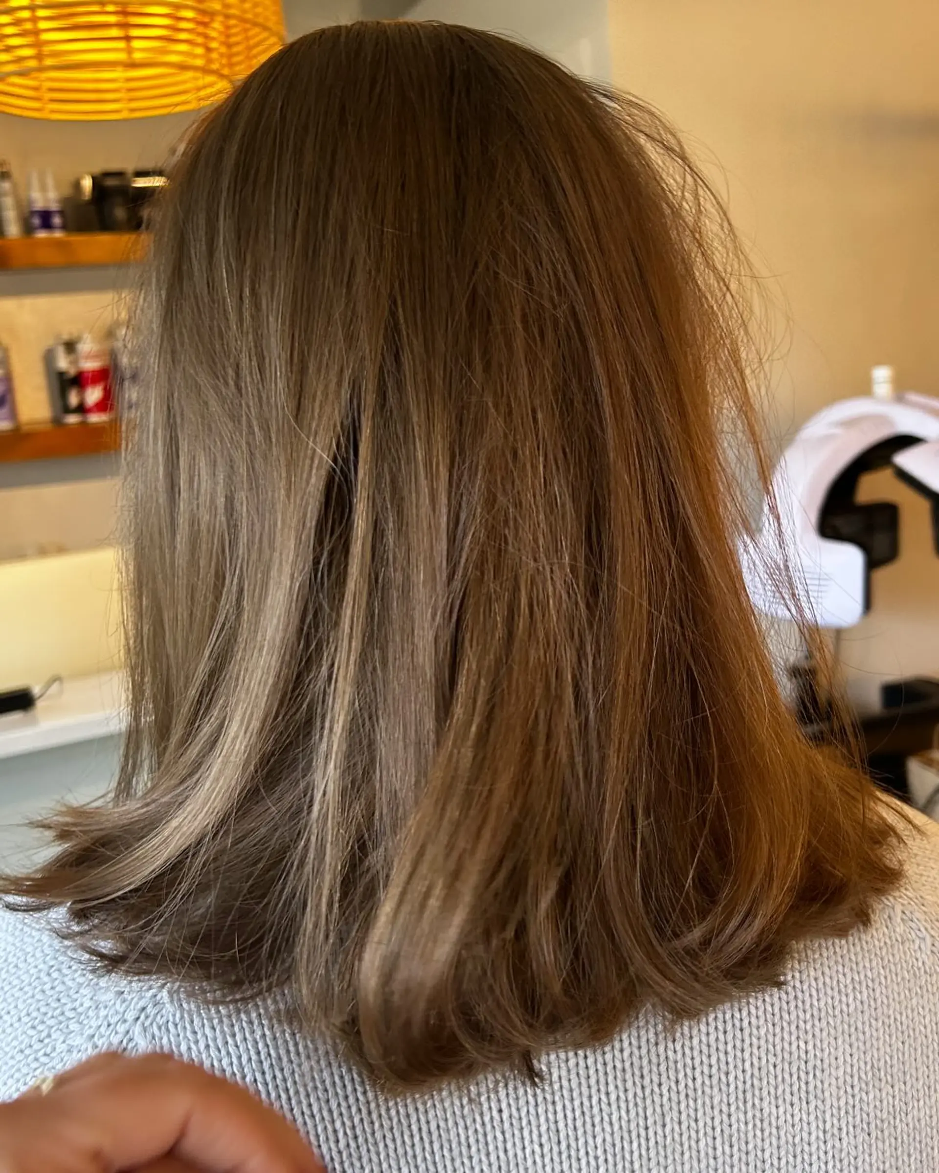 A medium-length layered long bob styled with a smooth finish and subtle movement at the ends. 1