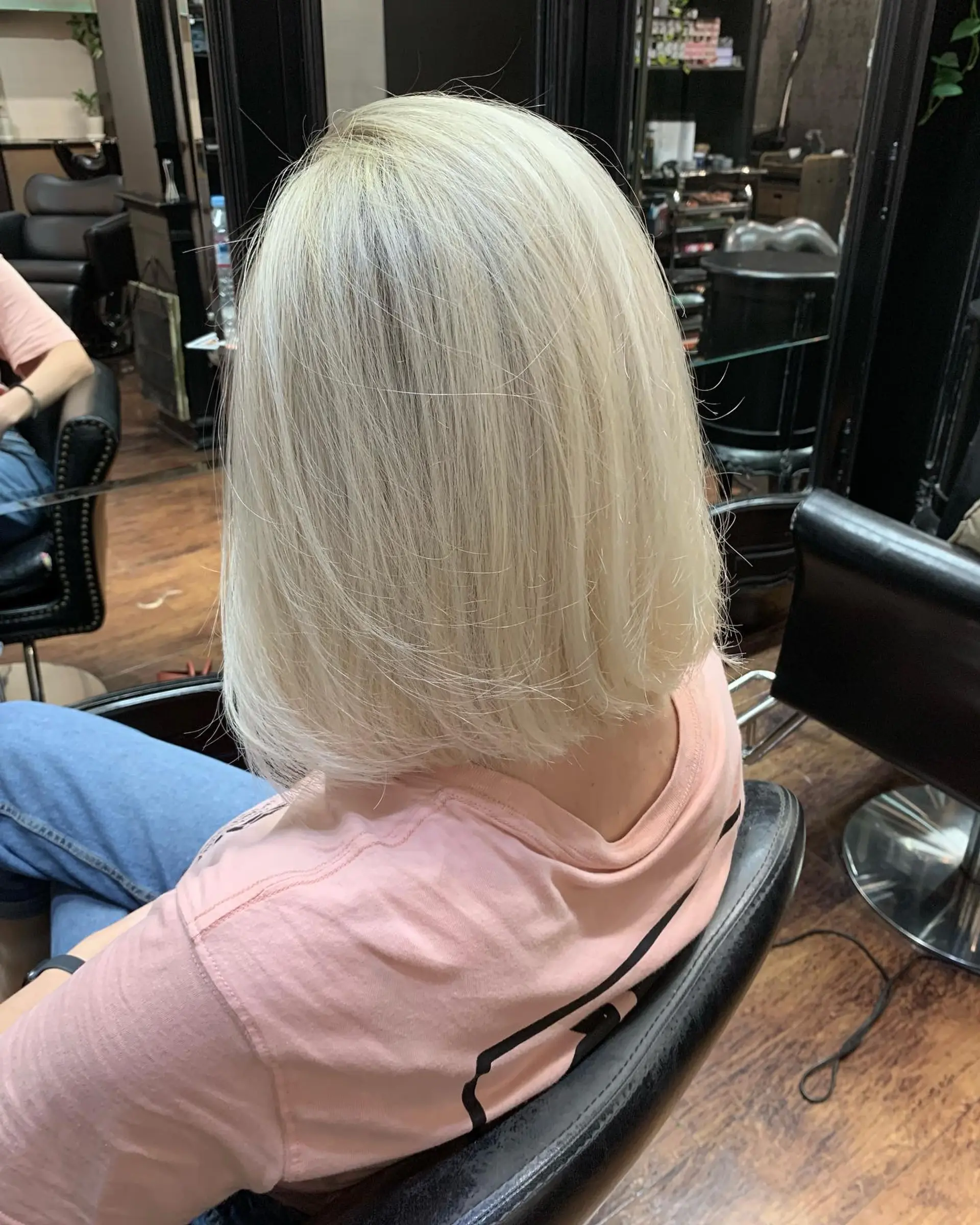 A sleek, shoulder-grazing platinum blonde bob cut with a clean blunt edge and straight styling. 1