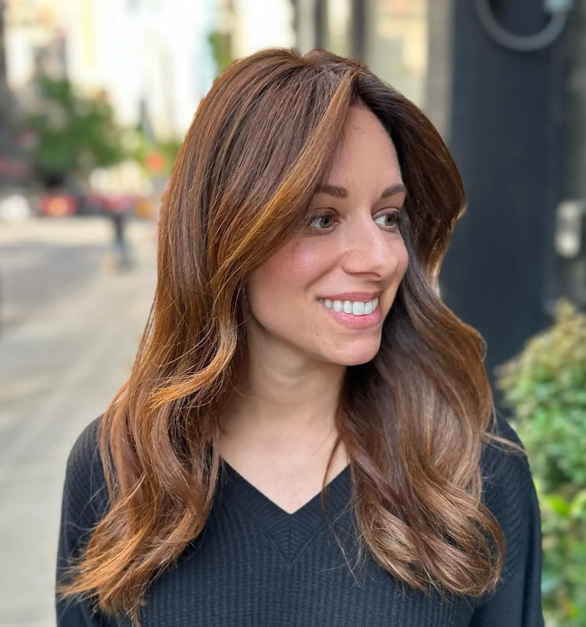 Long, light brown wavy hair with golden highlights, soft waves, face-framing layers, and a side part.

 1