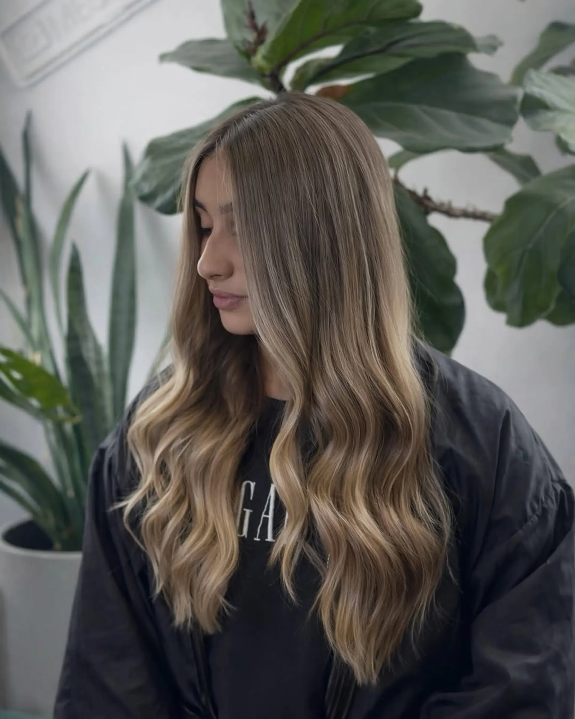 Long hair with soft, loose waves and a professional balayage color technique featuring blended dimensional blonde highlights. 1