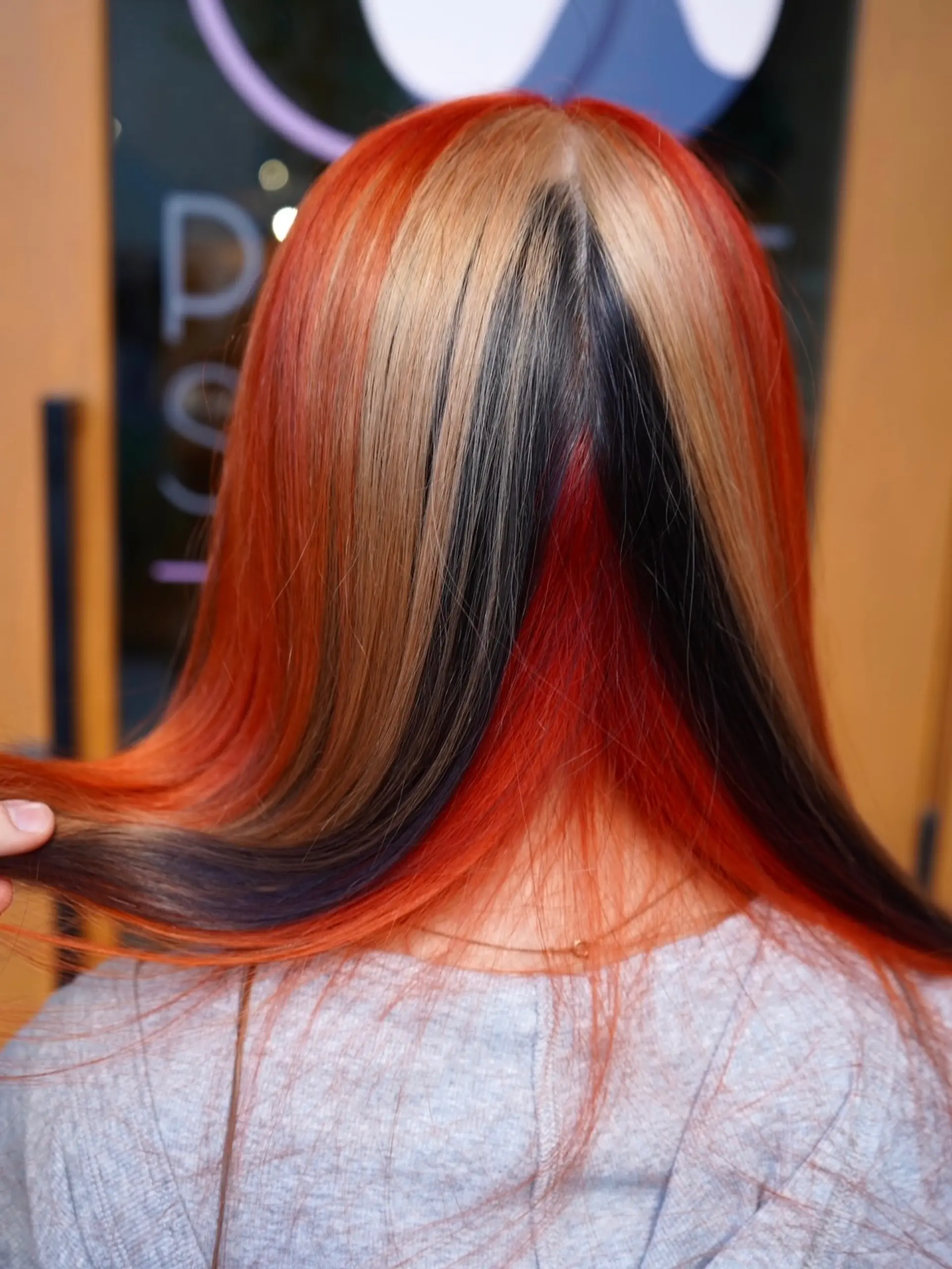 Straight long hair featuring a multi-tone calico color blocking with vivid orange, blonde, black, and red strands. 1