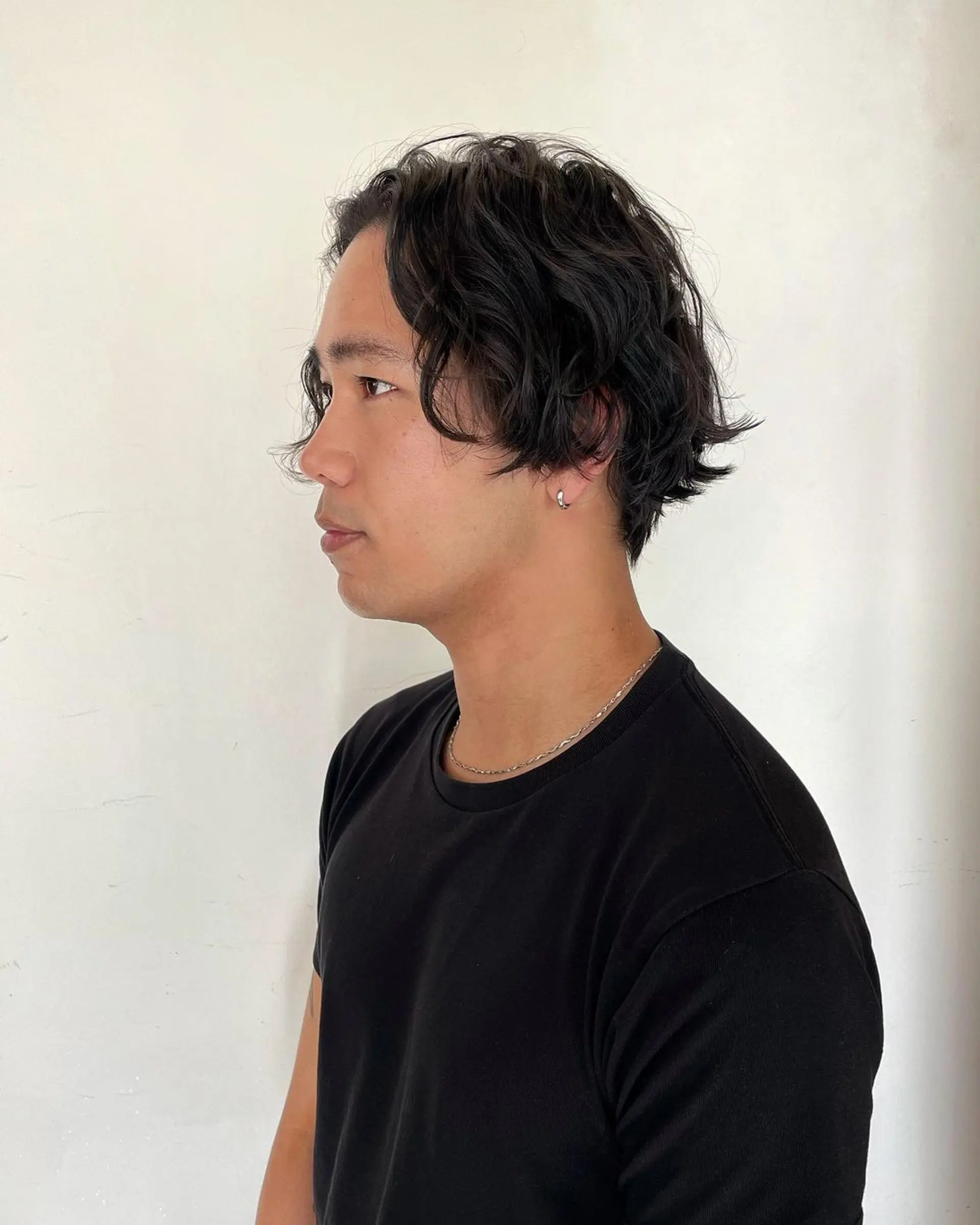 Medium length wavy hairstyle with a center part and ear-length waves, offering a casual and effortless appearance. 2