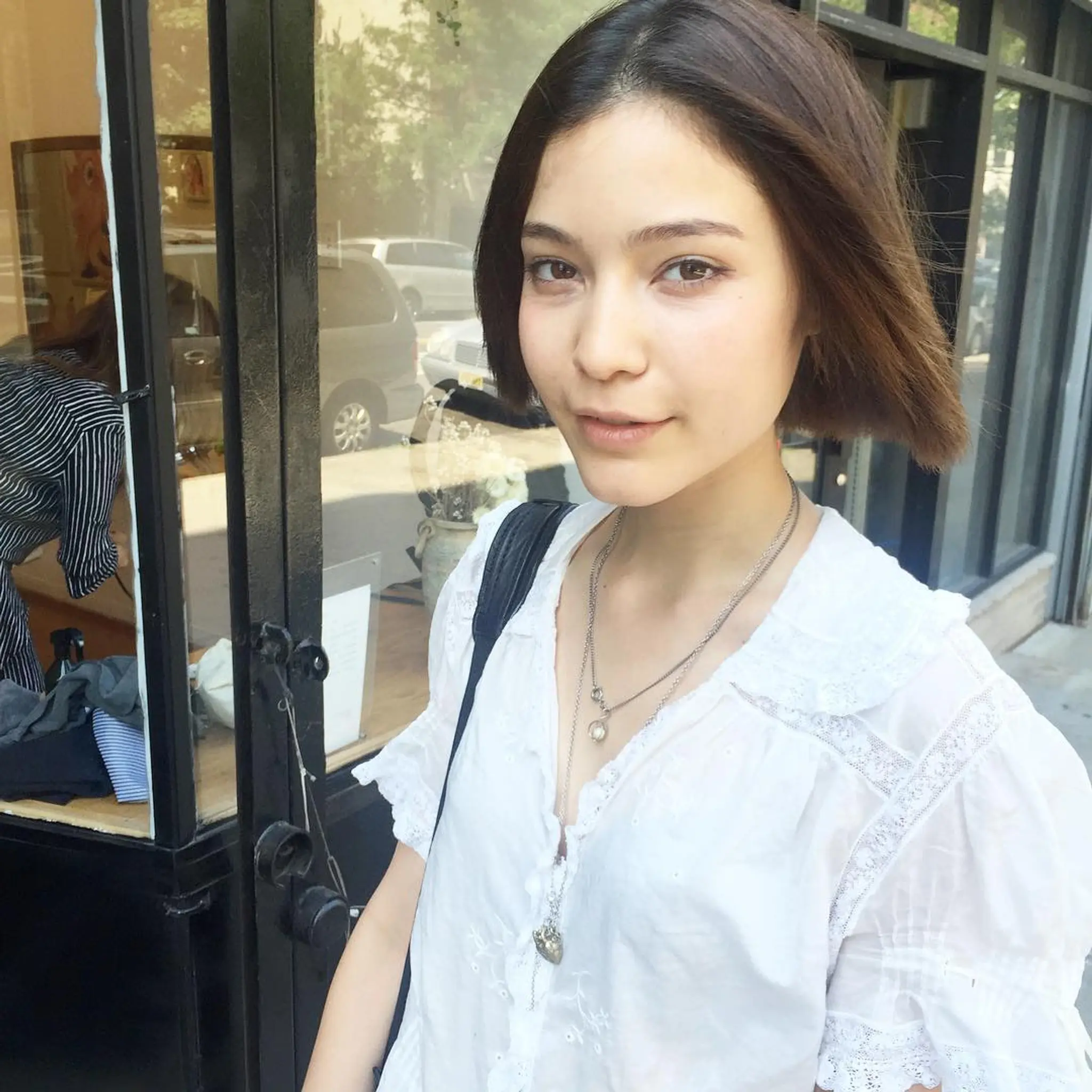 A sleek bob with straight, dark brown hair, featuring a center part and tapered ends for a smooth, polished look by Takeo.