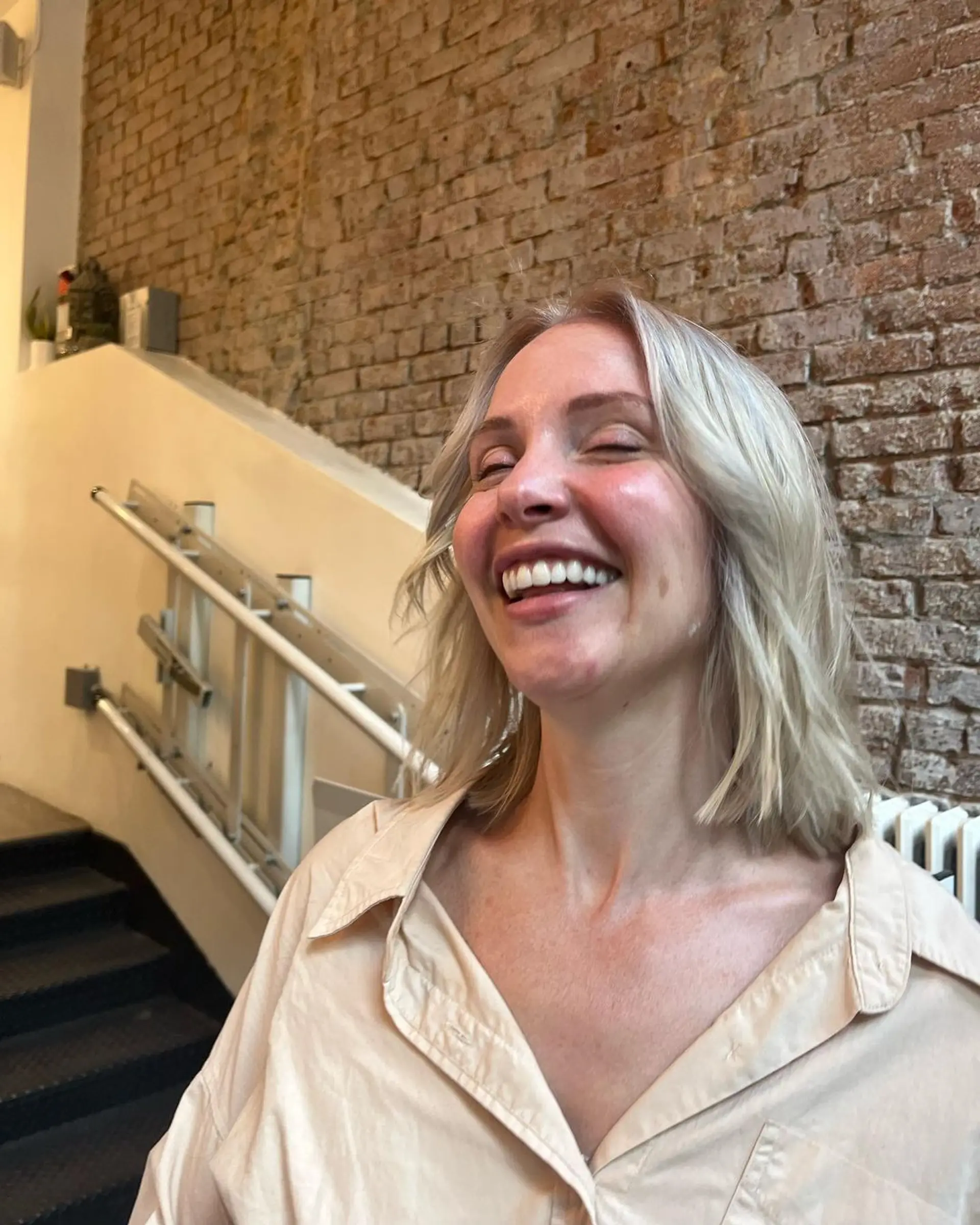 Medium-length platinum blonde hair with a wavy texture, side part, soft layers, and face-framing pieces. 2