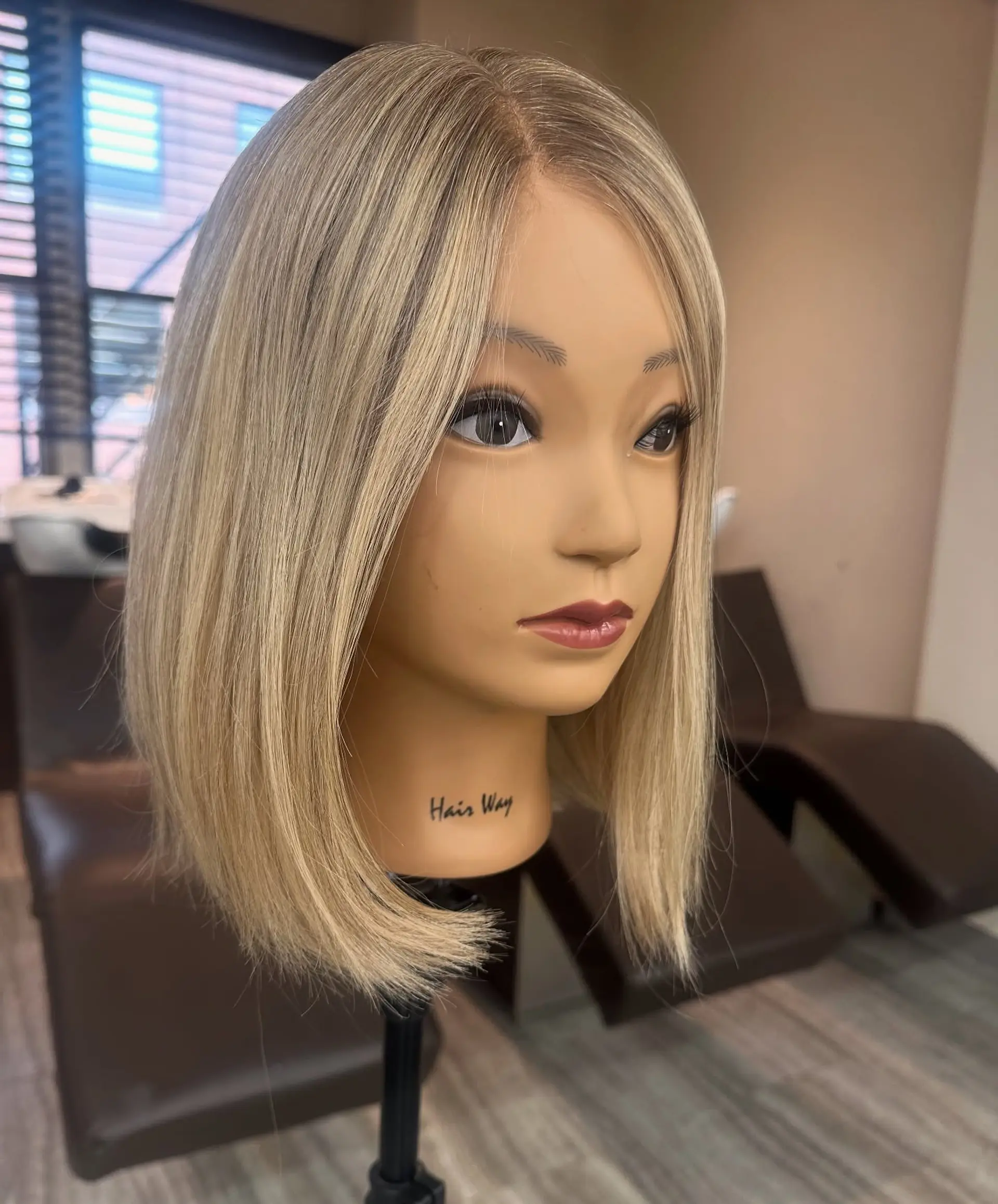 A sleek, straight shoulder-length blunt bob featuring neutral blonde highlights and soft lowlights. 1