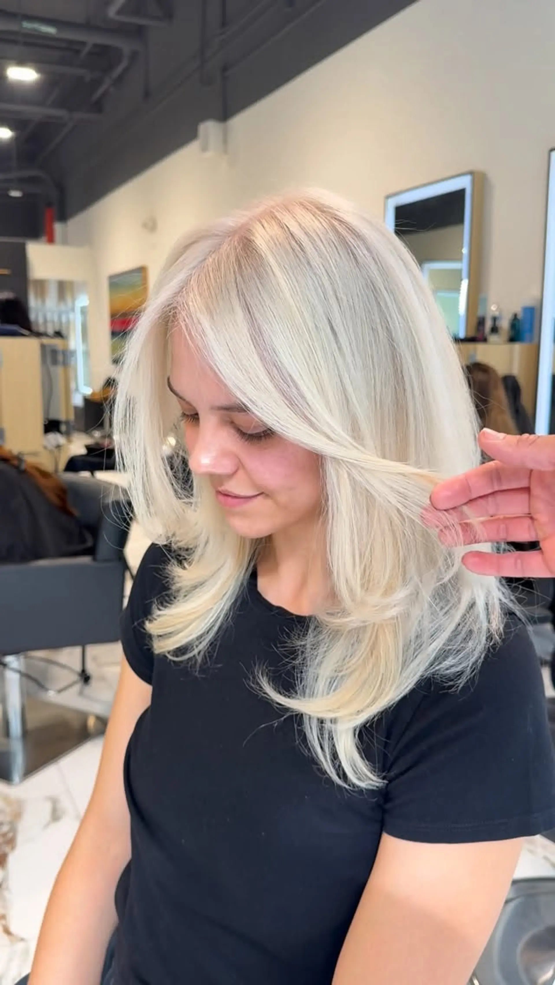 Bright platinum blonde medium-length hair styled with face-framing layers and smooth, turned-in ends. 1