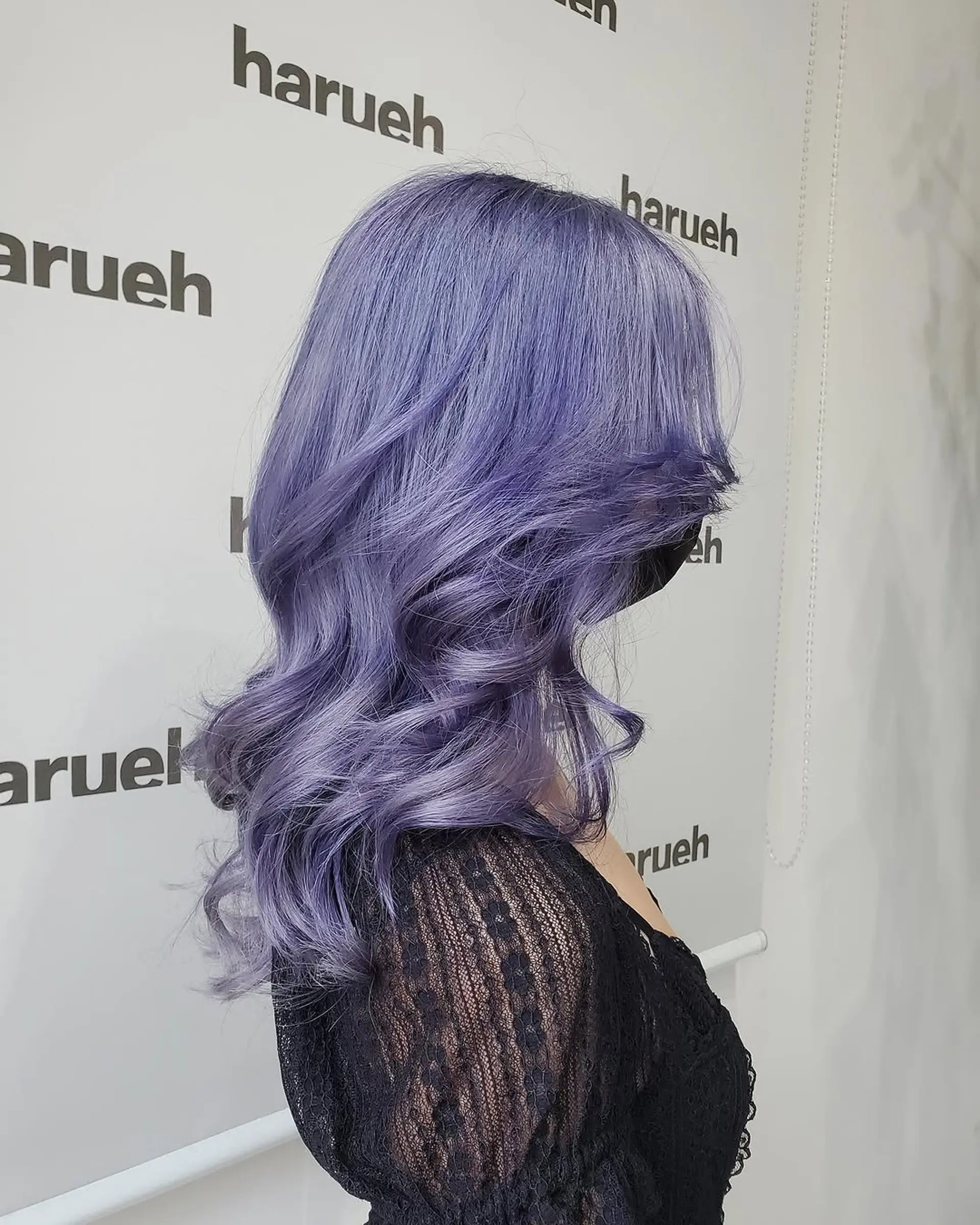 A textured medium-length cut with soft, voluminous waves and face-framing layers, colored in a striking pastel lavender. 1
